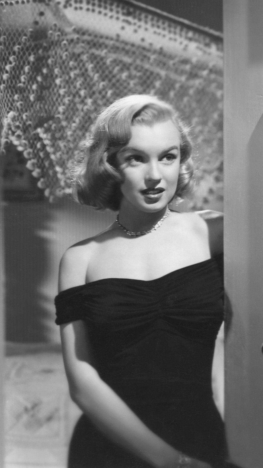 A black and white photo of a woman in a black dress - Marilyn Monroe