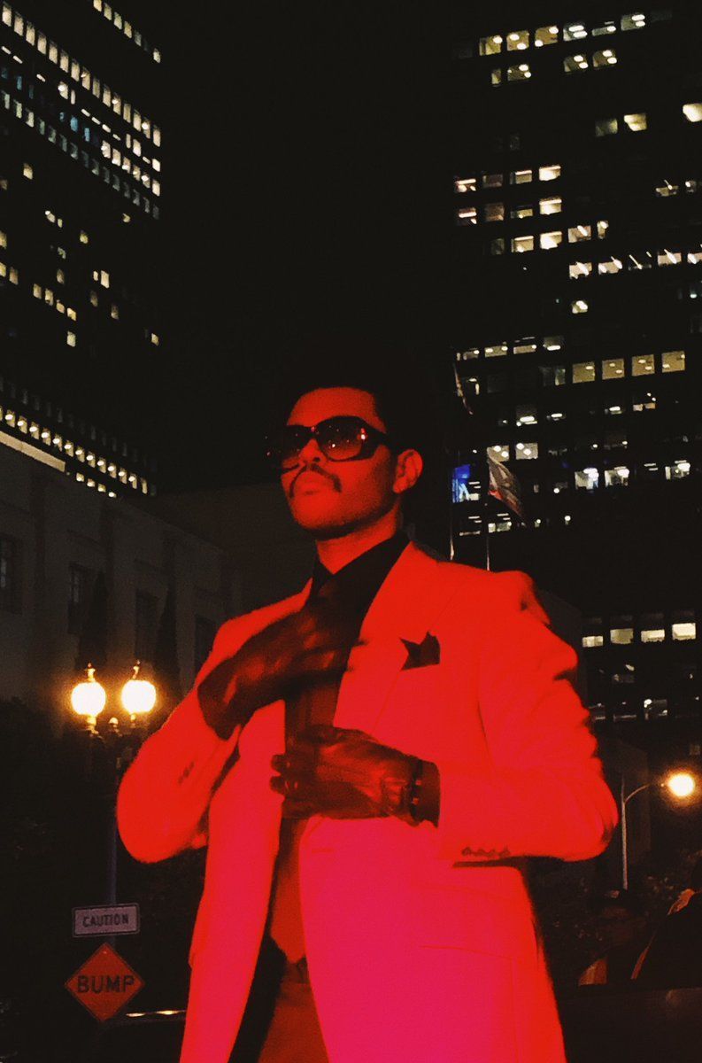 A man in red suit and tie posing - The Weeknd