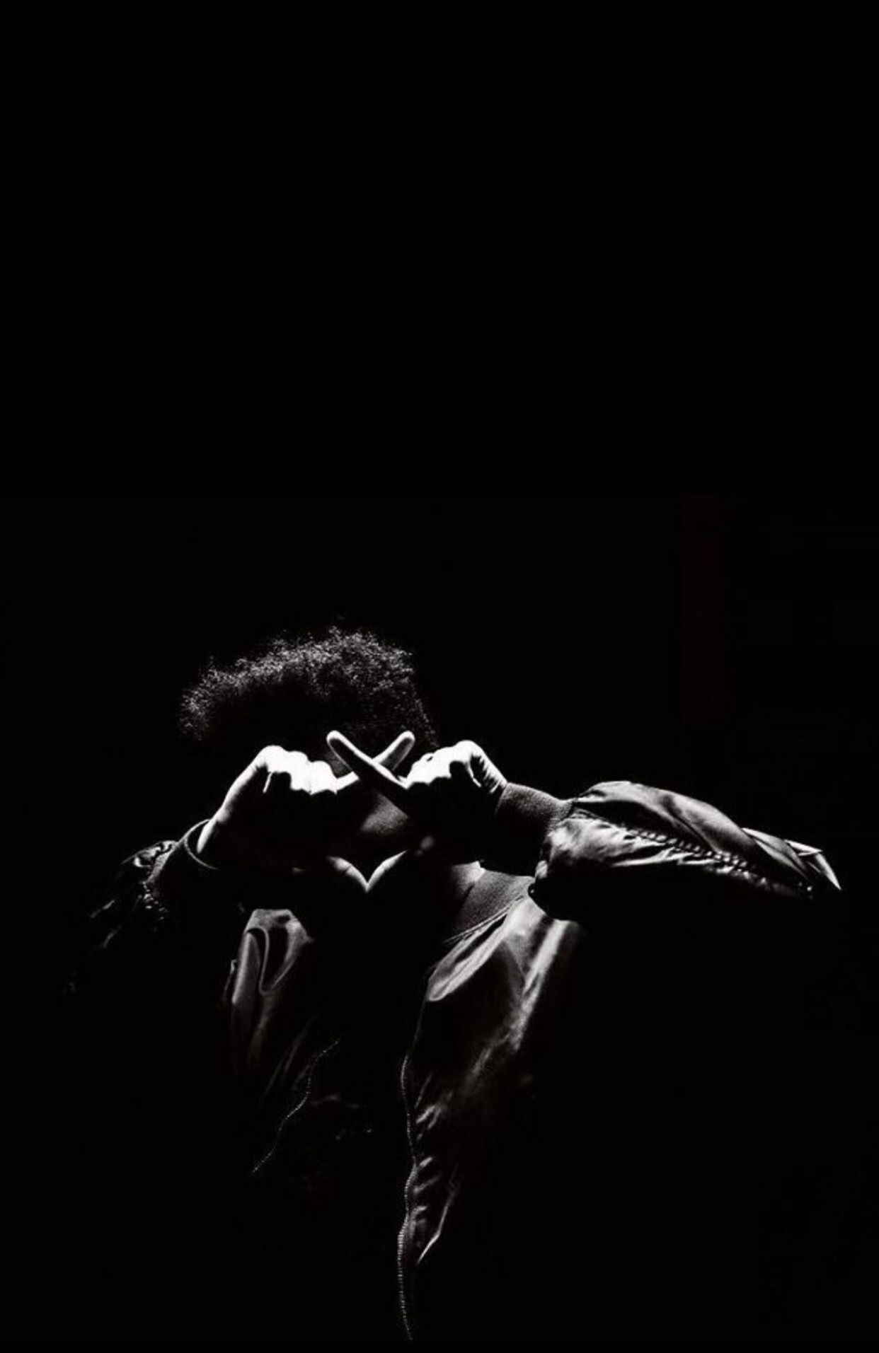 A man in a black and white photo with his hands in the shape of a heart. - The Weeknd