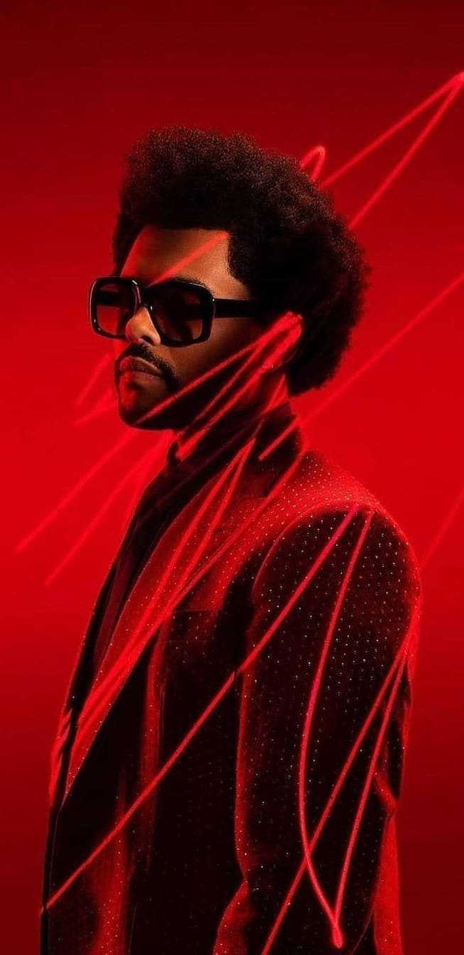 A man with an afro and sunglasses in red - The Weeknd