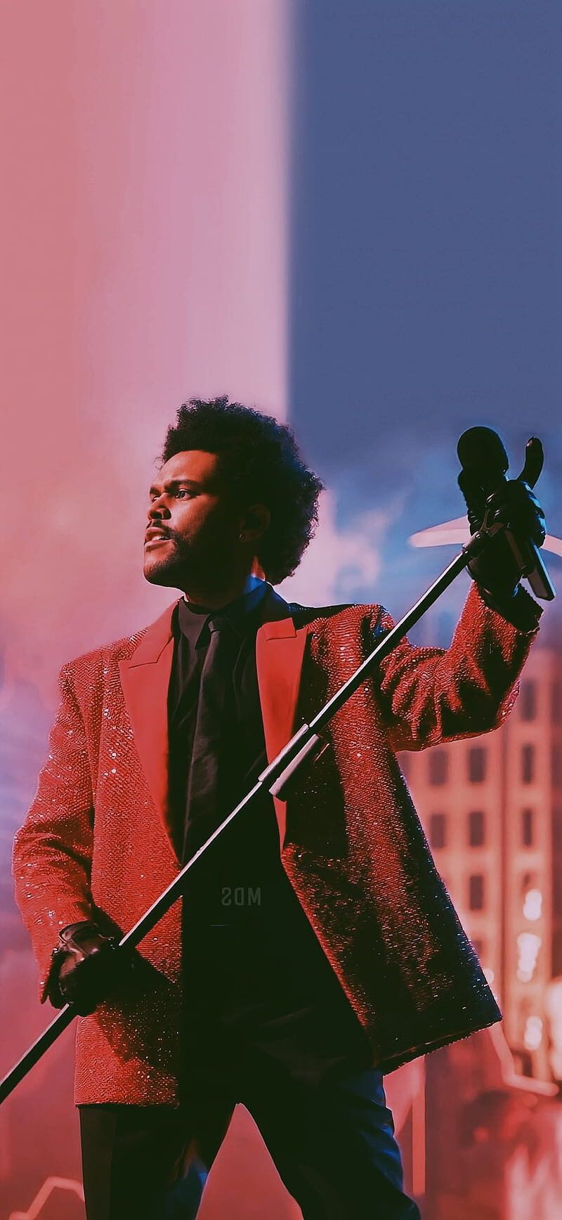 A man holding an umbrella and wearing red - The Weeknd