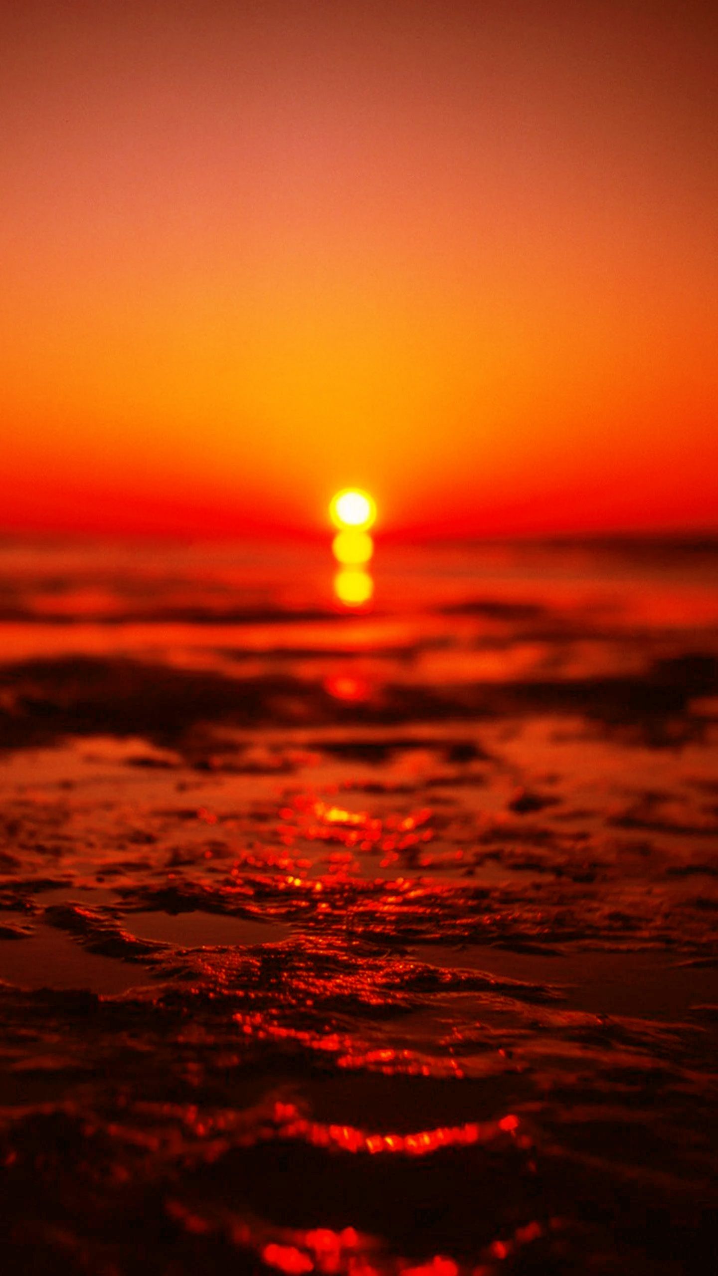 A beautiful sunset over the ocean with the sun setting below the horizon - Sunset