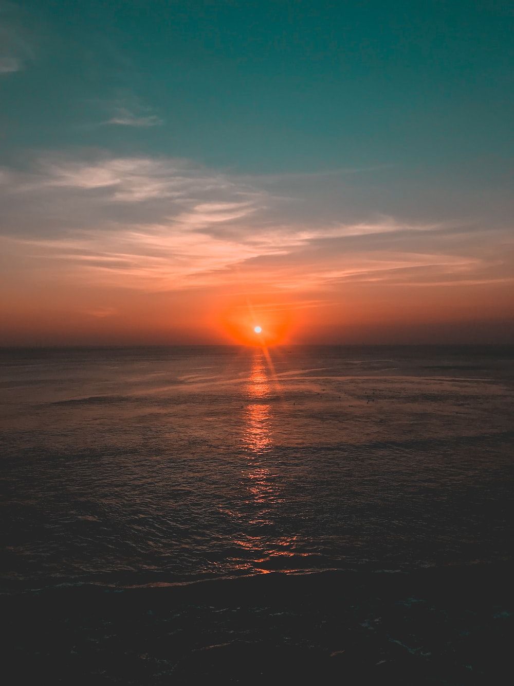 The sun setting over the ocean - Sunset