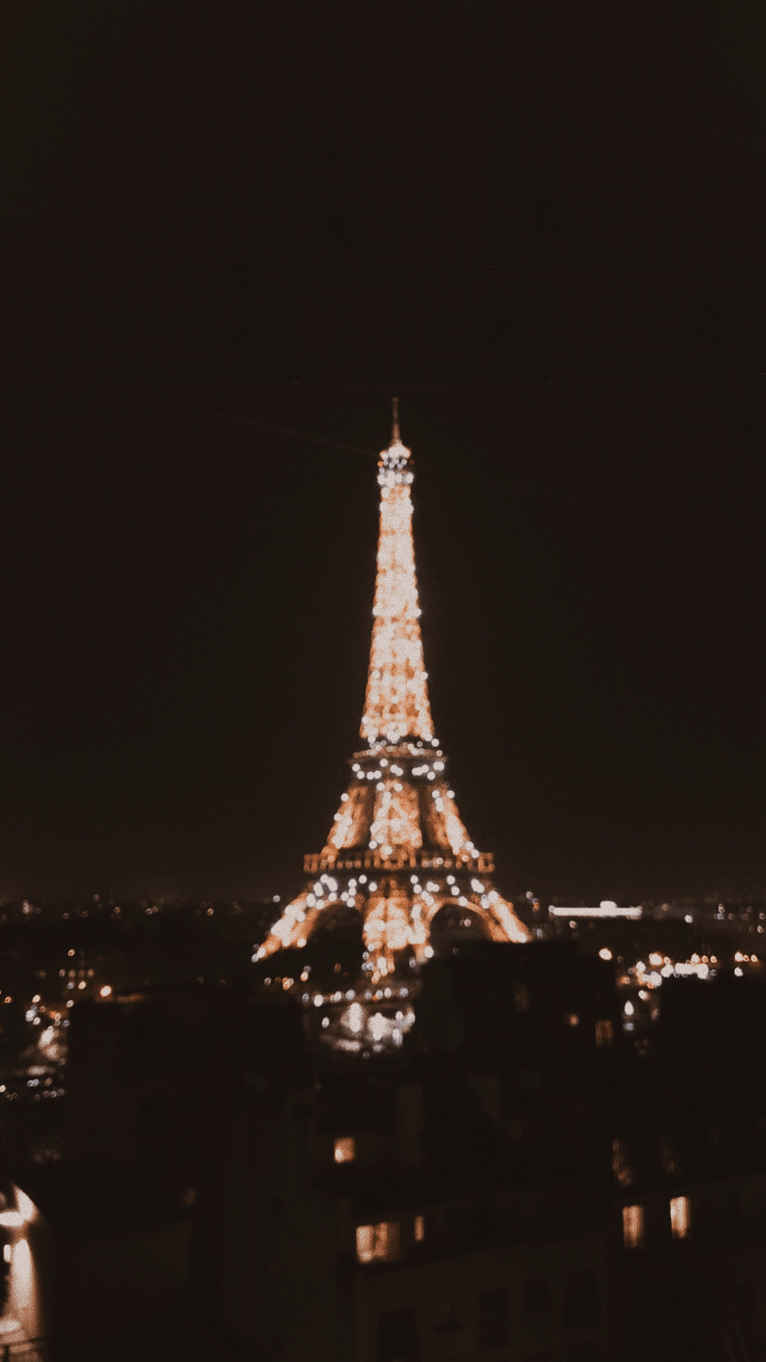 A blurry photo of the Eiffel Tower lit up at night. - Paris, Eiffel Tower