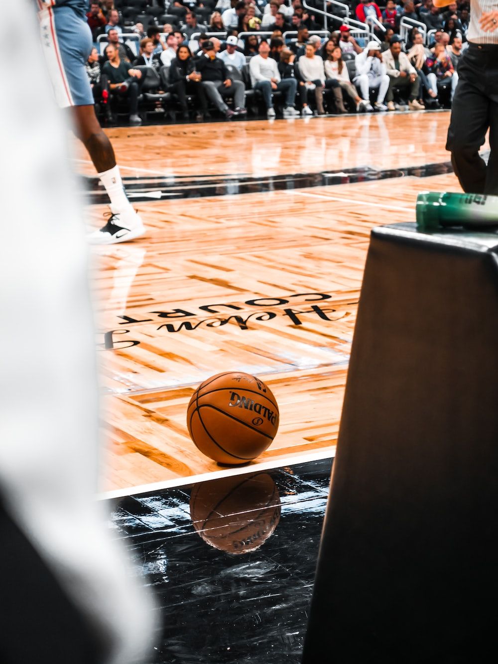 A basketball on the floor of an arena - NBA