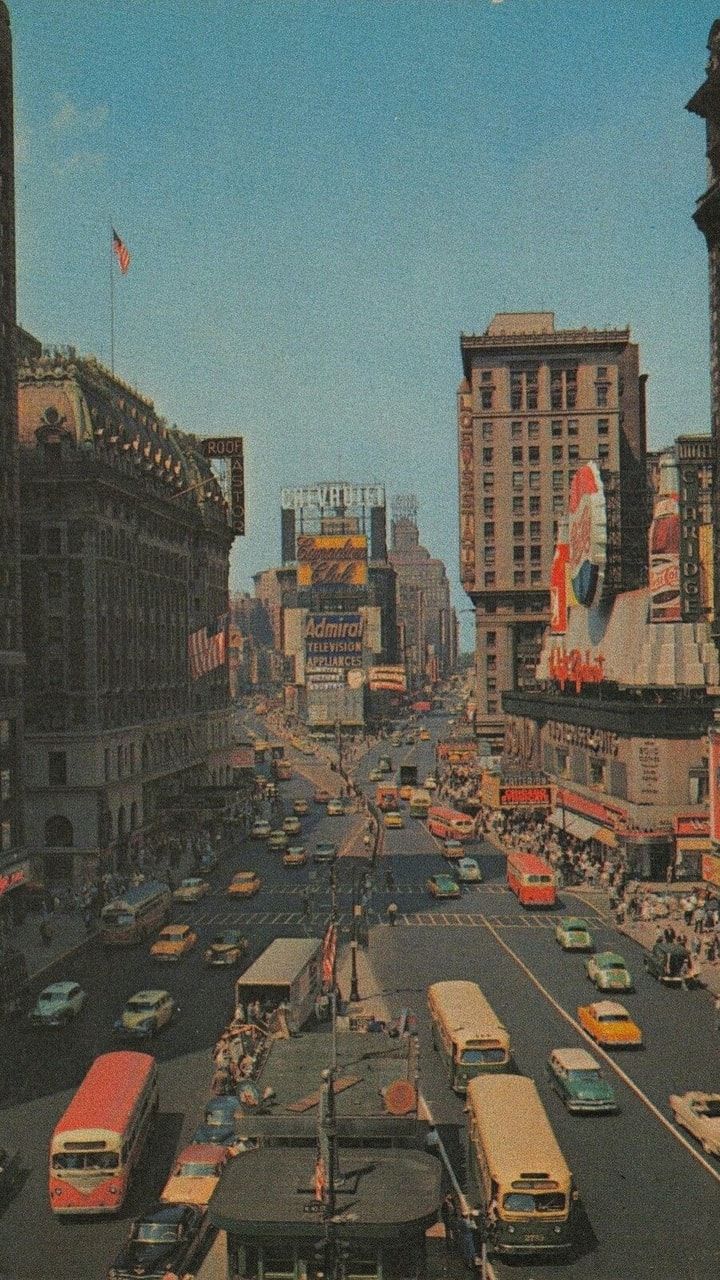 A city street with many cars and buses - 60s