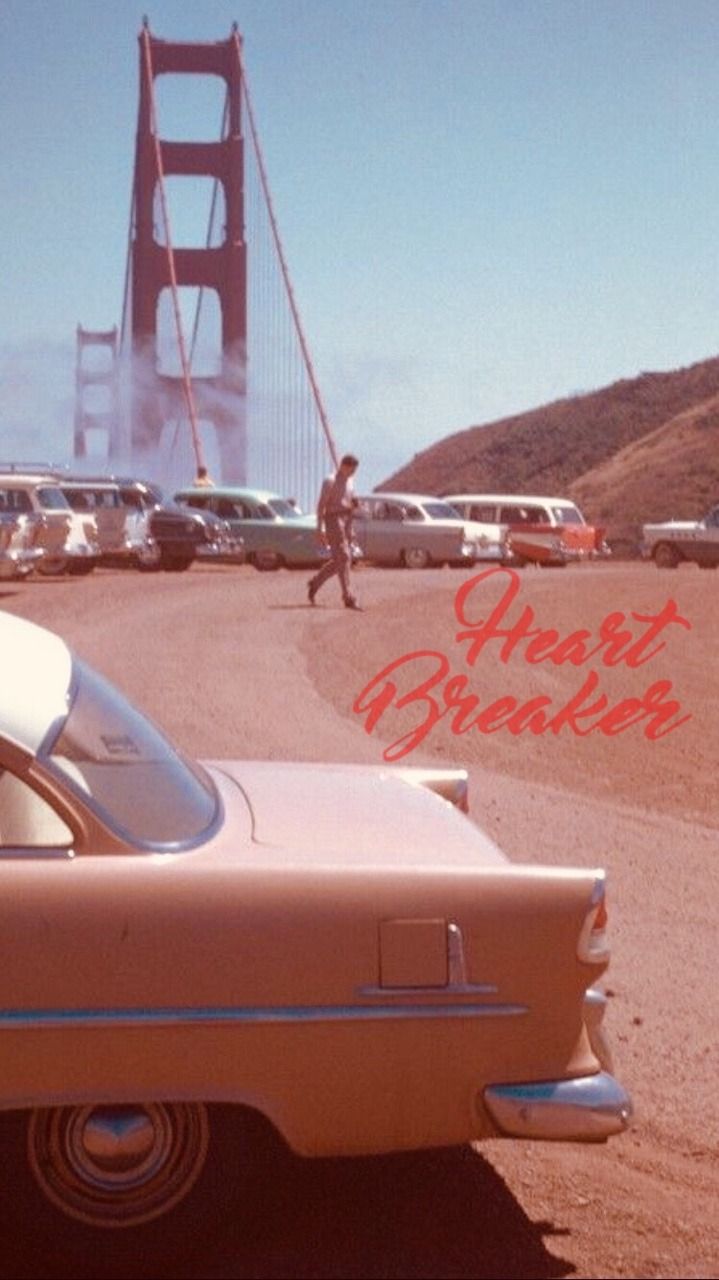A man walking in front of the Golden Gate Bridge with a pink car in the foreground. - Vintage, 60s, 50s, California