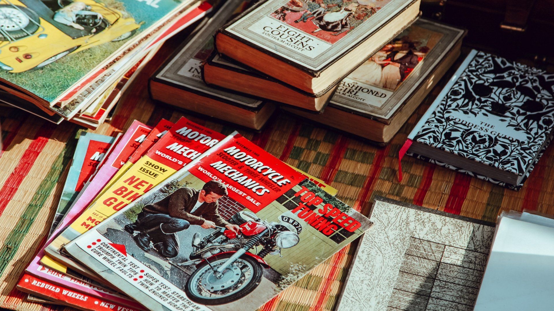 A pile of books including a magazine on motor cycle mechanics - 60s