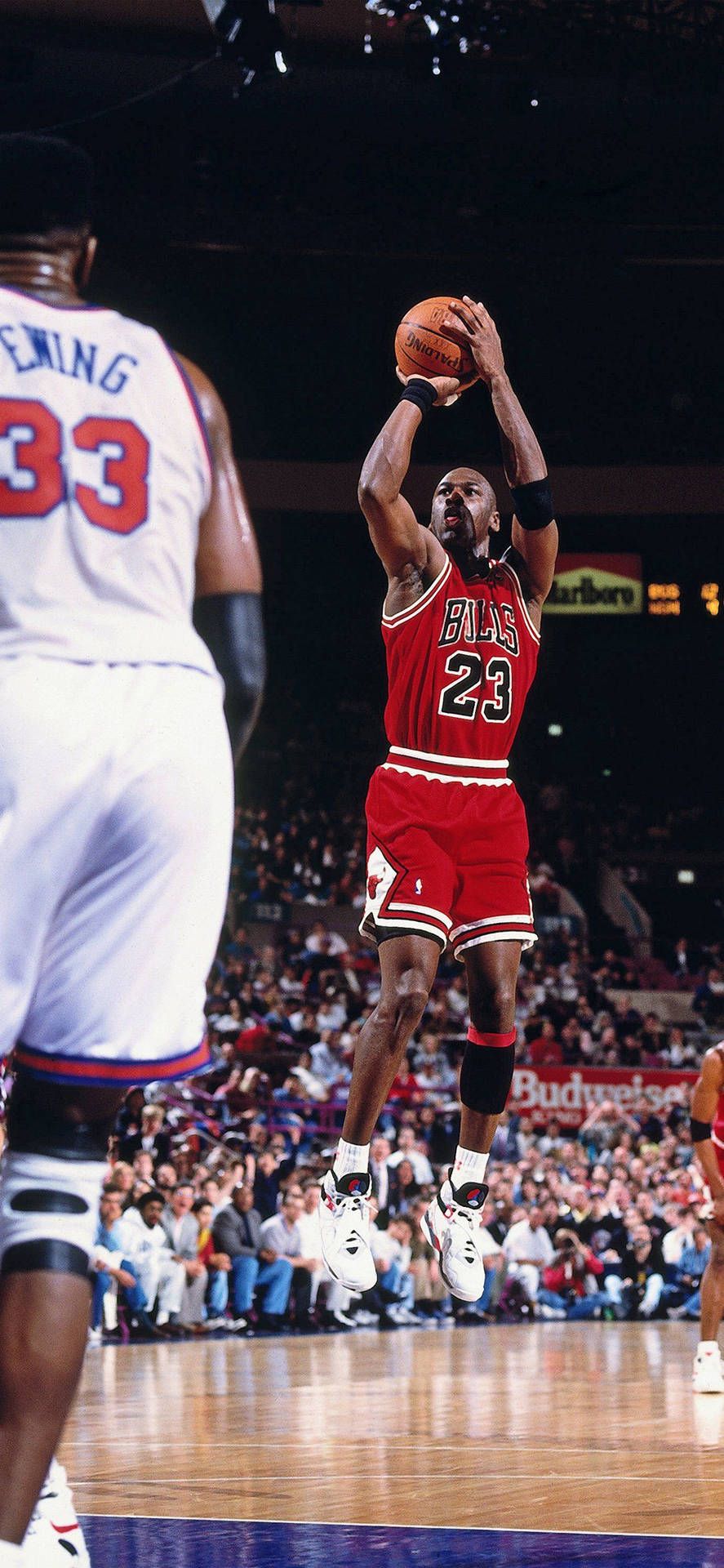 Jordan in red jersey and black wristband shoots the ball - NBA