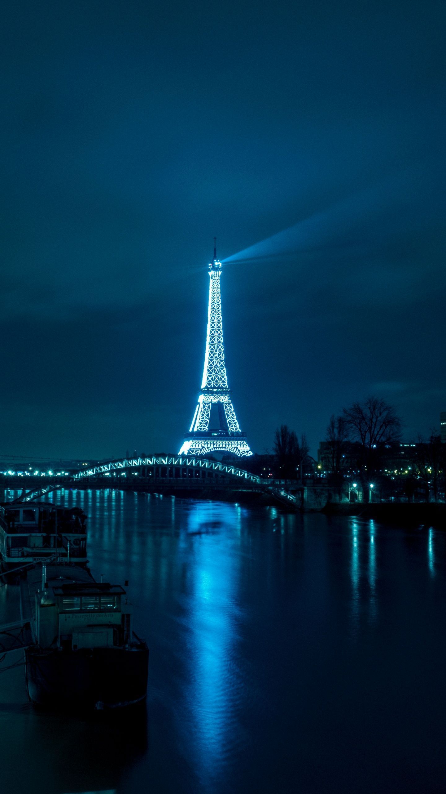 The Eiffel Tower lit up at night, seen from across the river. - Paris, France, Eiffel Tower