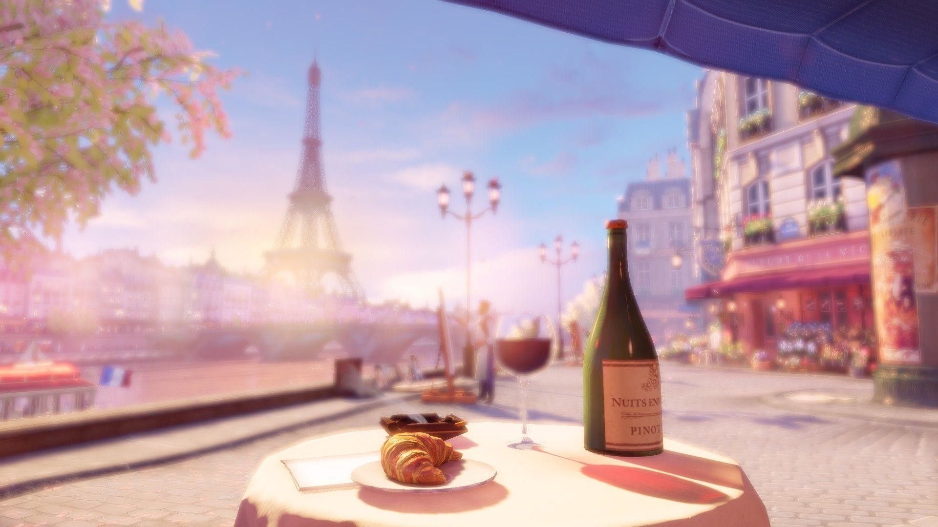 A bottle of wine and a pastry sit on a table in front of the Eiffel Tower. - Paris