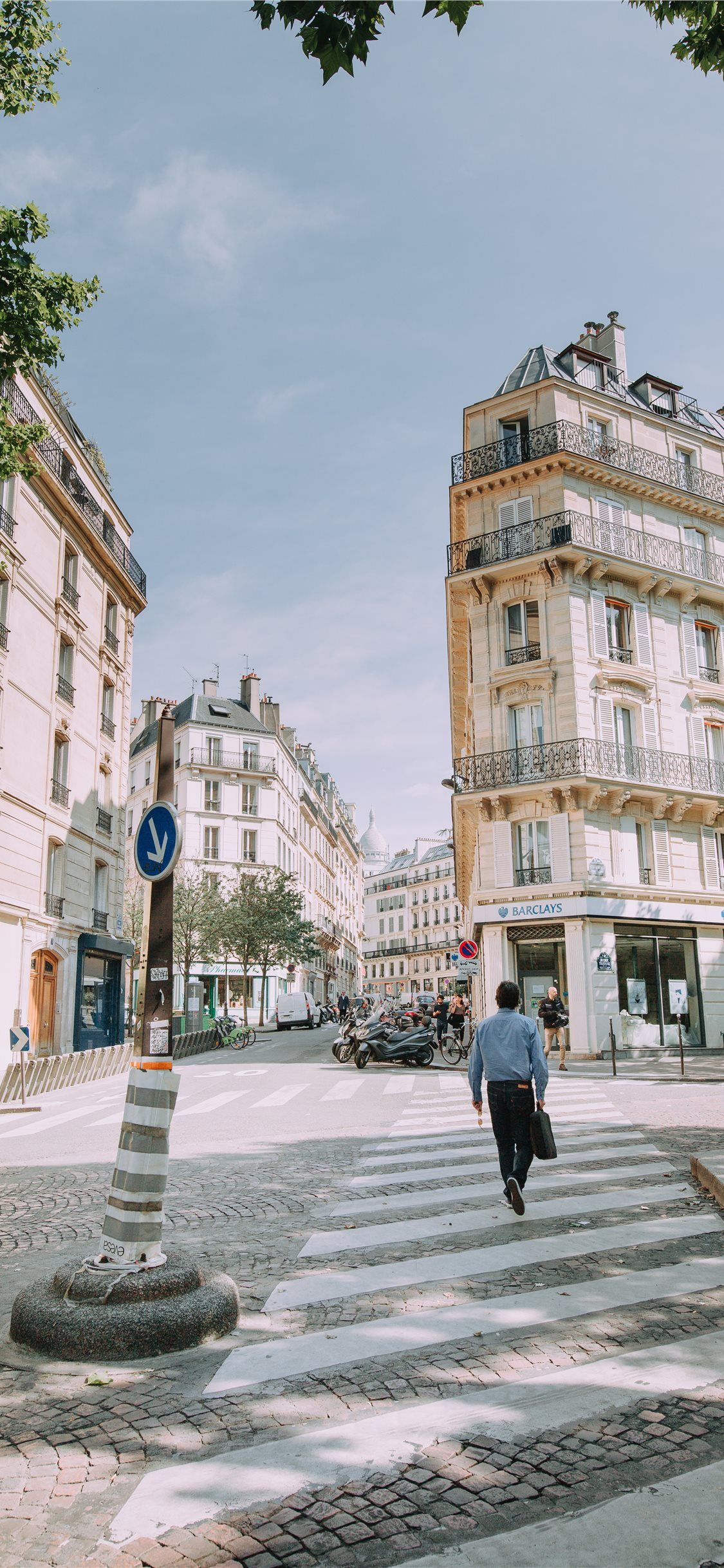 A man walking across the street in front of buildings - Paris, travel