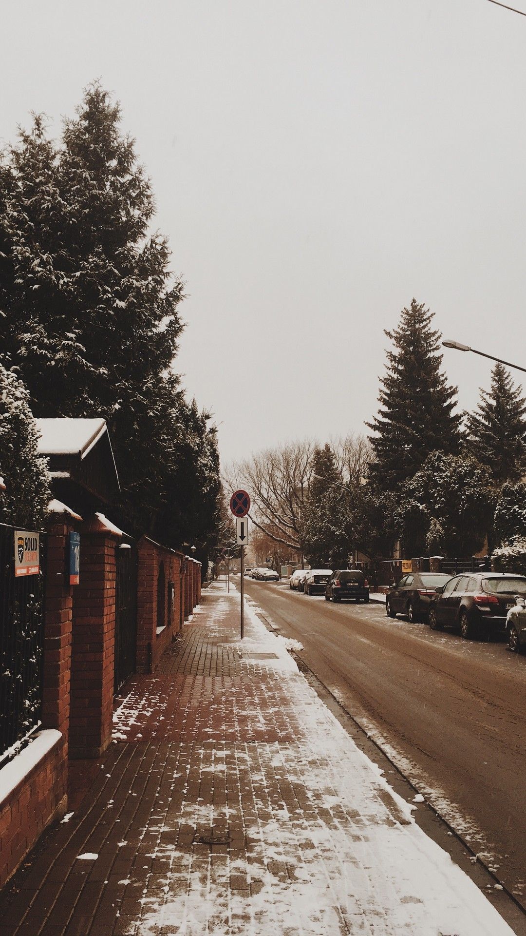A street with cars parked on it and snow - Los Angeles, winter