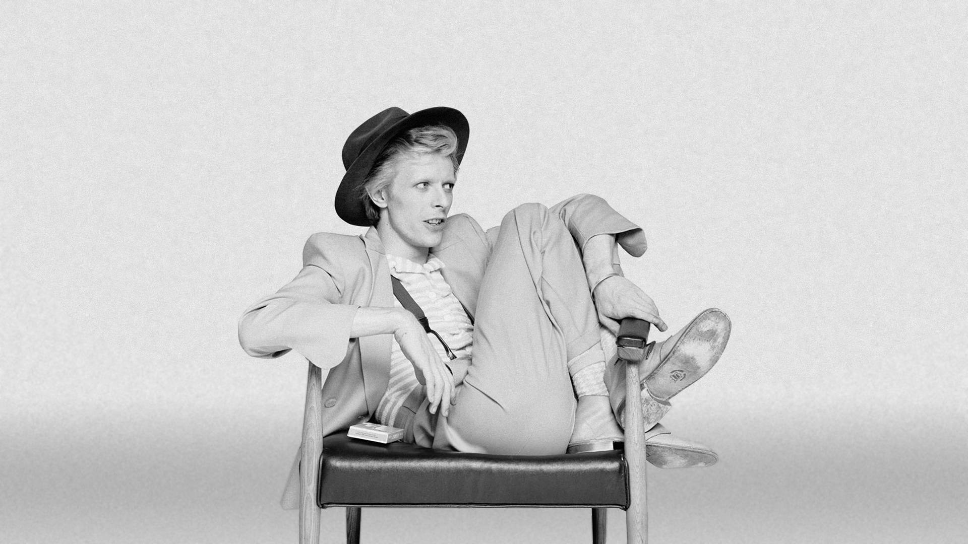 A person sitting in an office chair - David Bowie