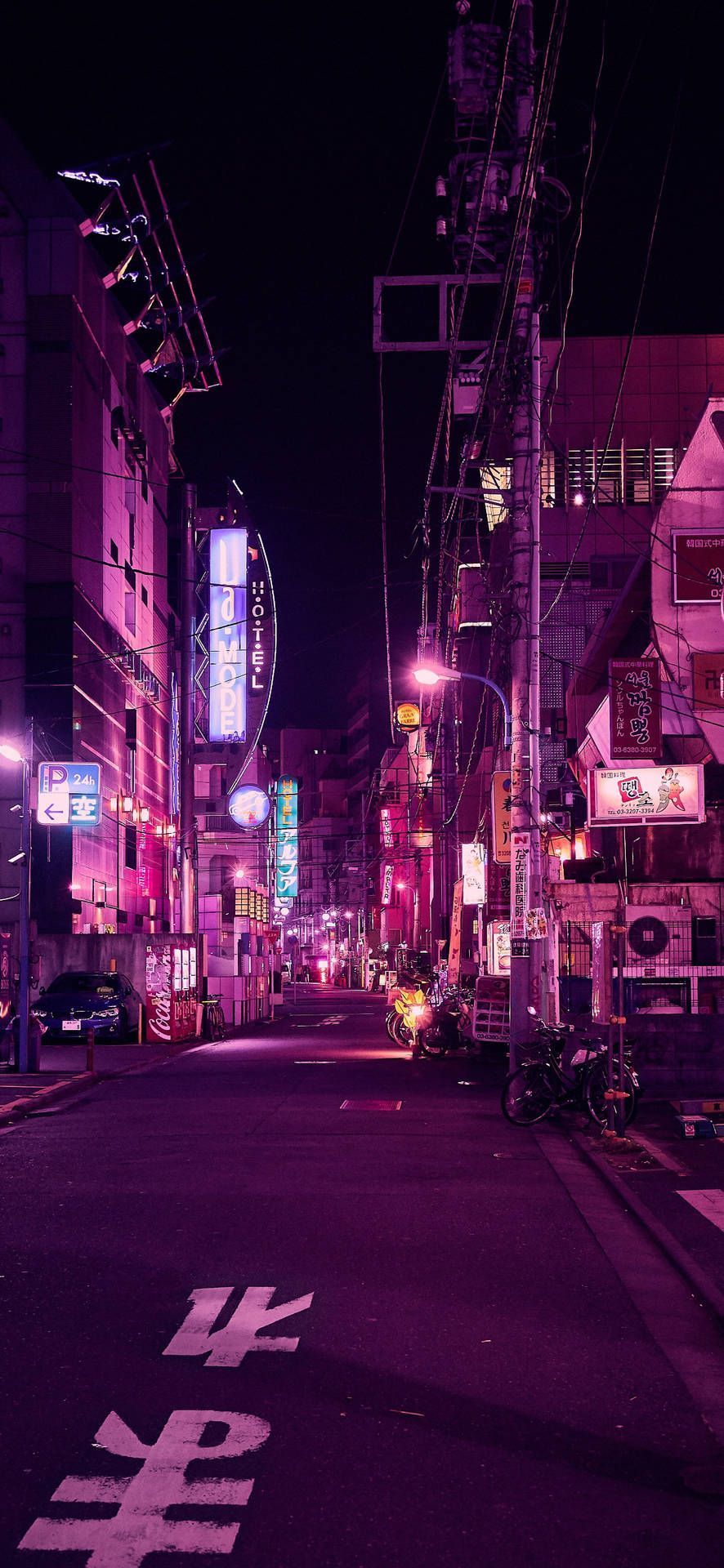 A city street at night with pink lighting - Tokyo