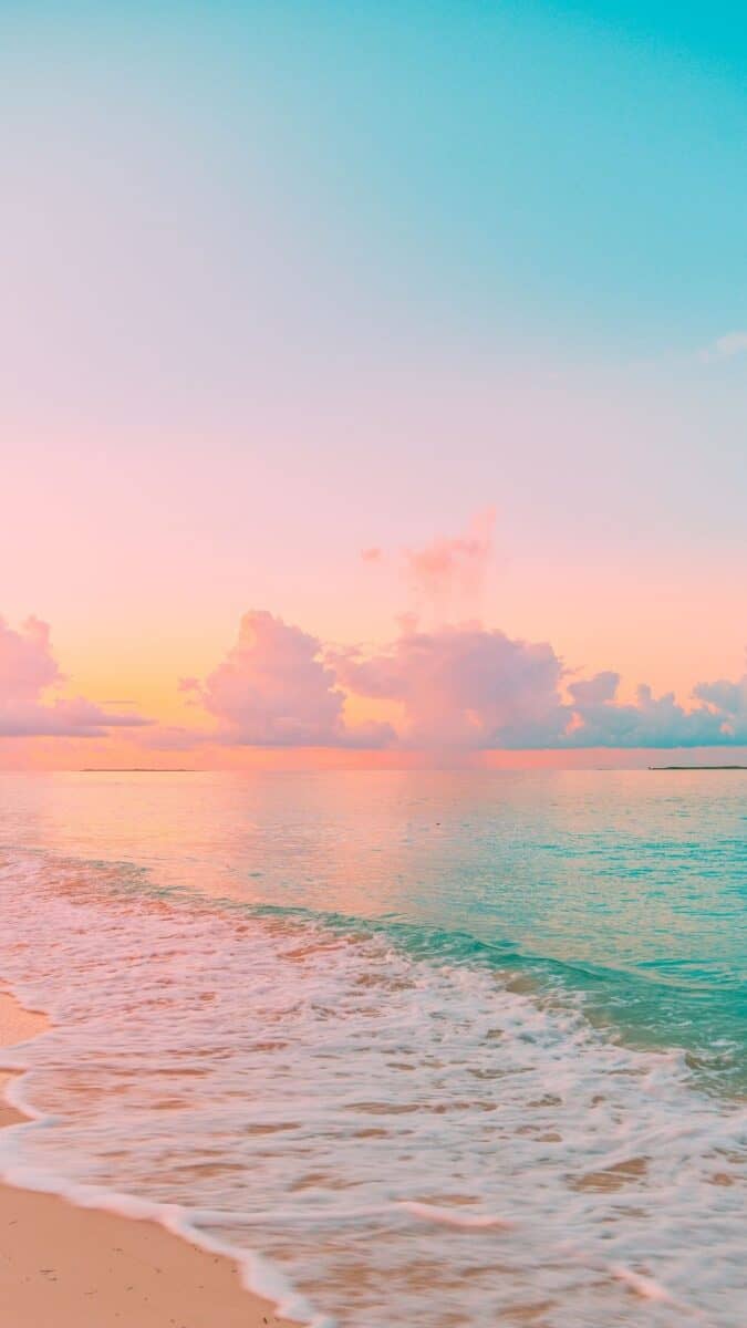 A beach with the ocean and sky painted in pastel colors - Summer