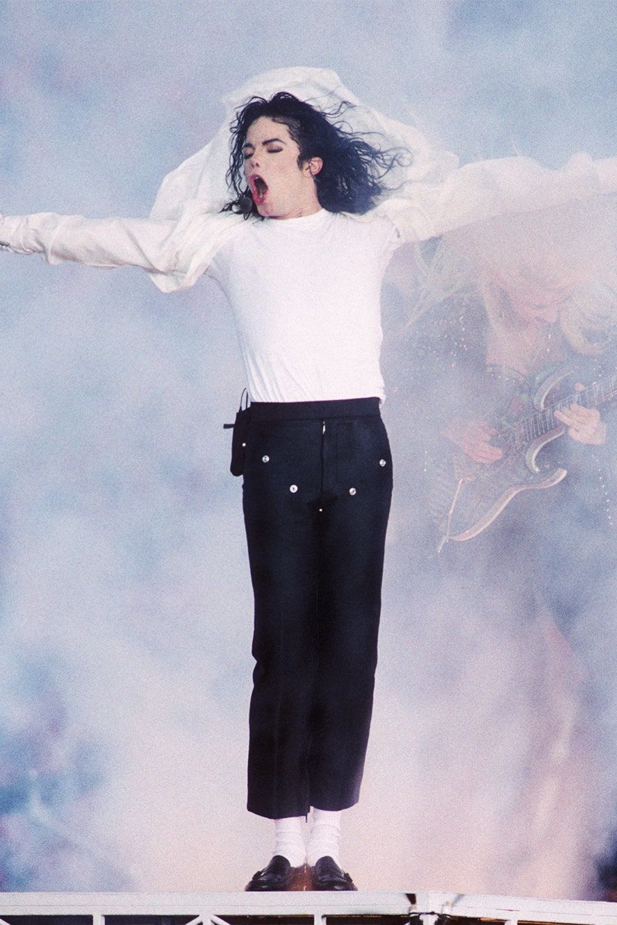 Michael Jackson performing on stage in a white shirt and black pants. - Michael Jackson