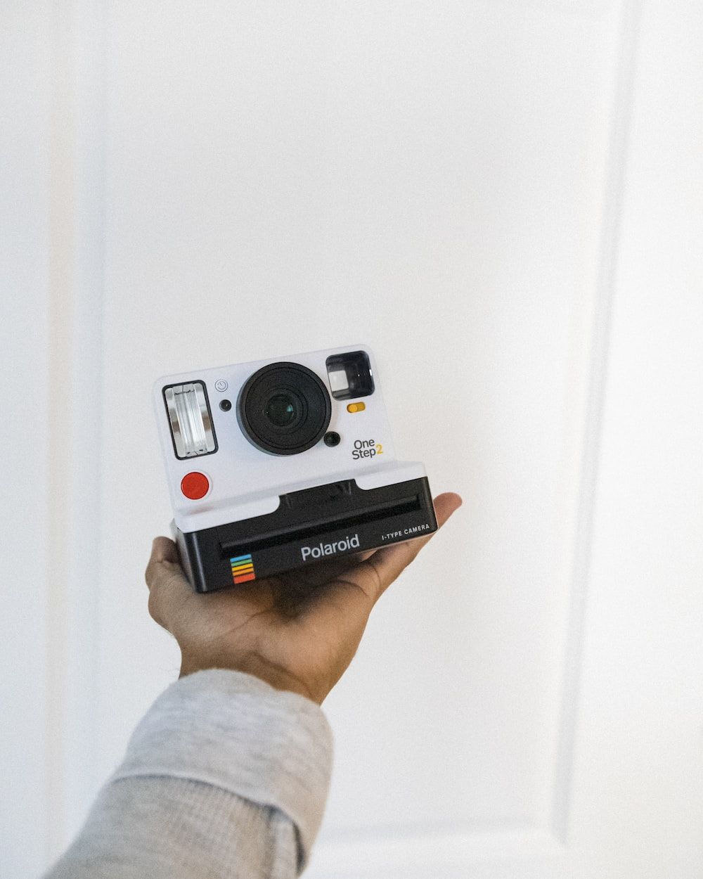 Person holding polaroid camera on white background - Polaroid