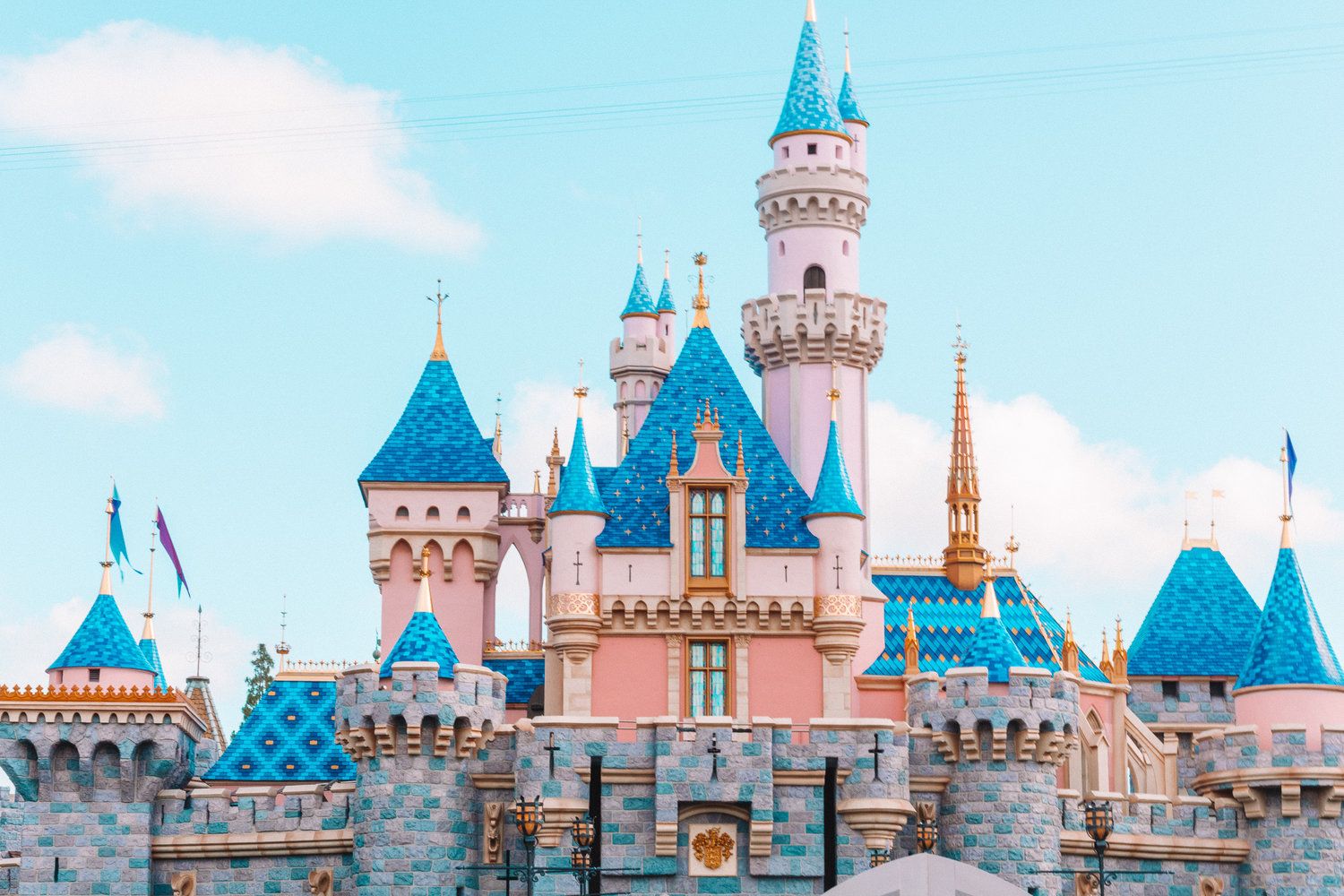 A large castle with blue and pink towers - Disneyland