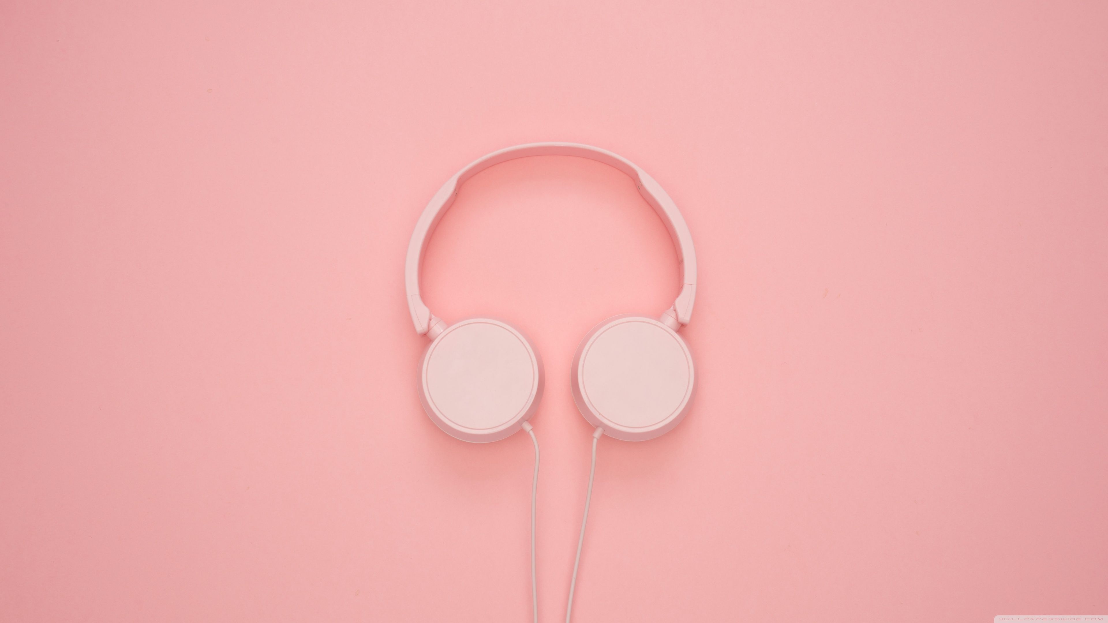 A pair of white headphones on a pink background - 3840x2160