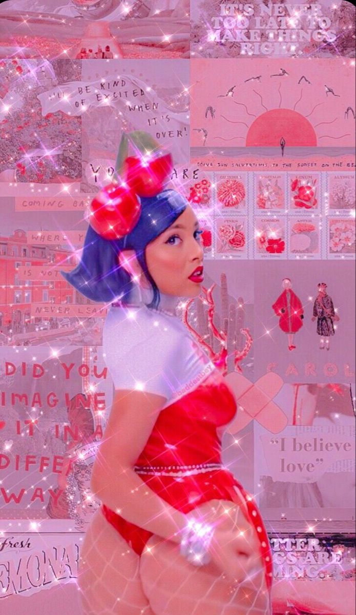 A woman with blue hair and a red dress in front of a pink wall - Doja Cat