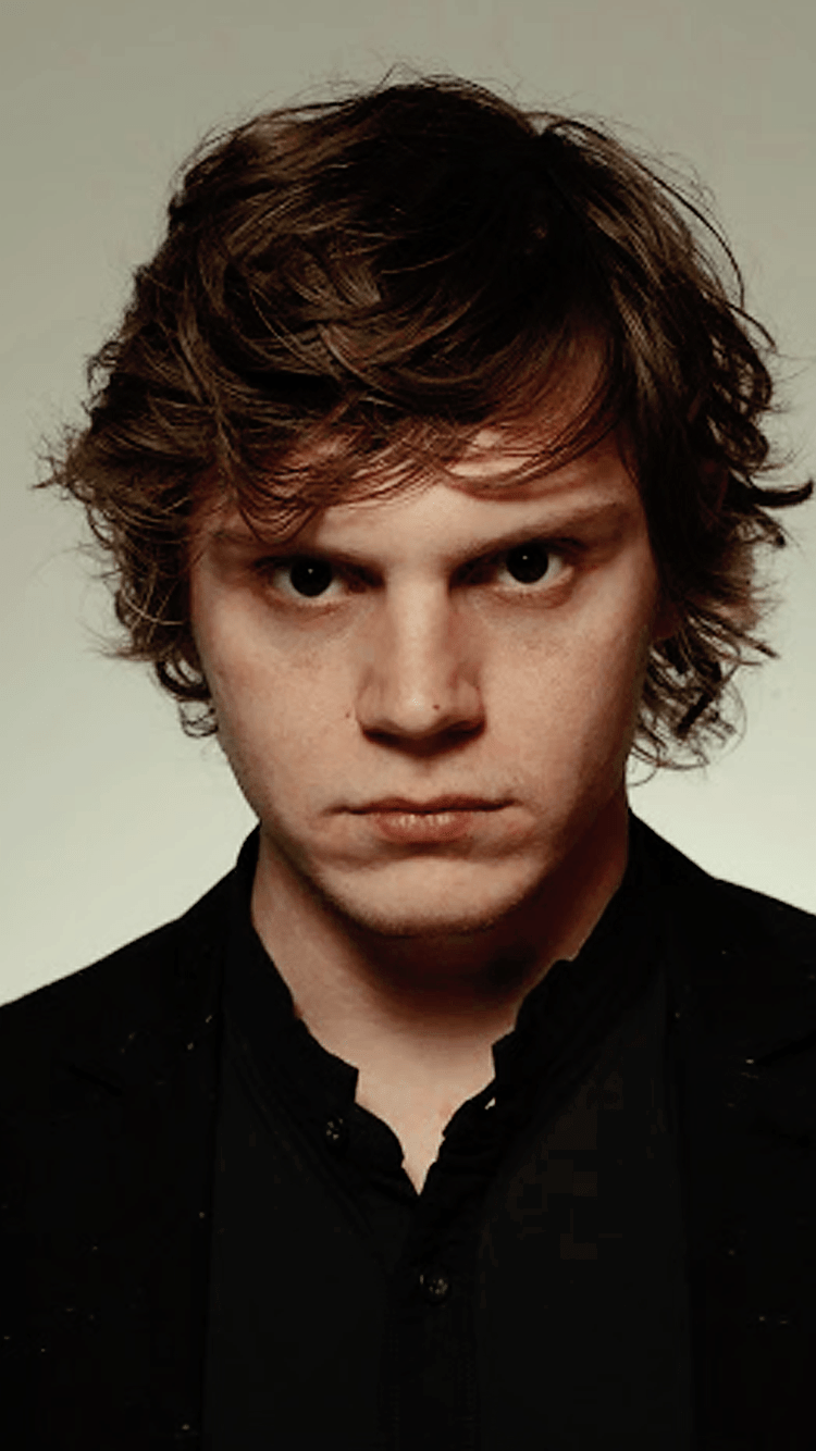 A man with long hair and black suit - Evan Peters