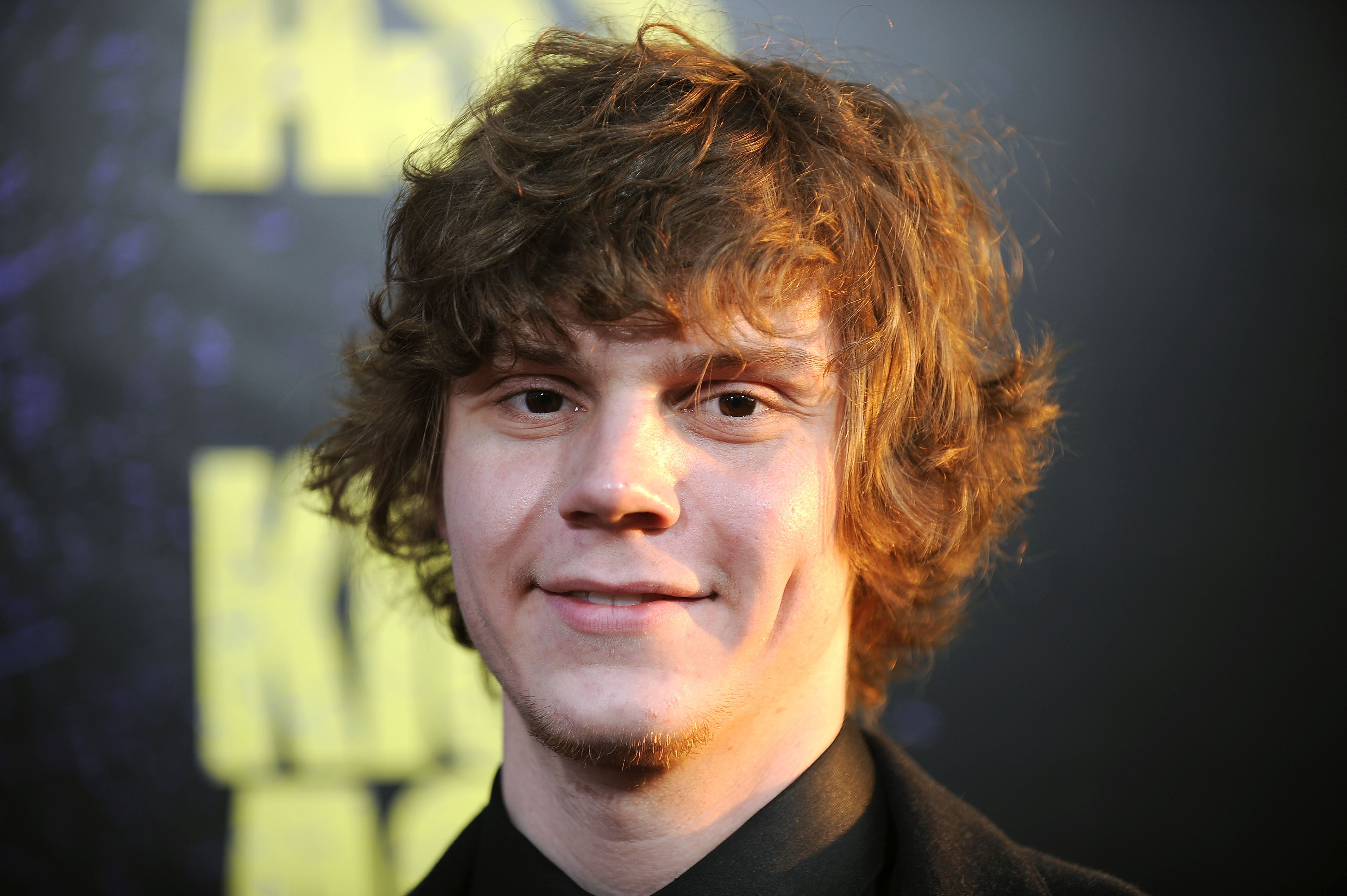 A young man with curly hair and glasses - Evan Peters