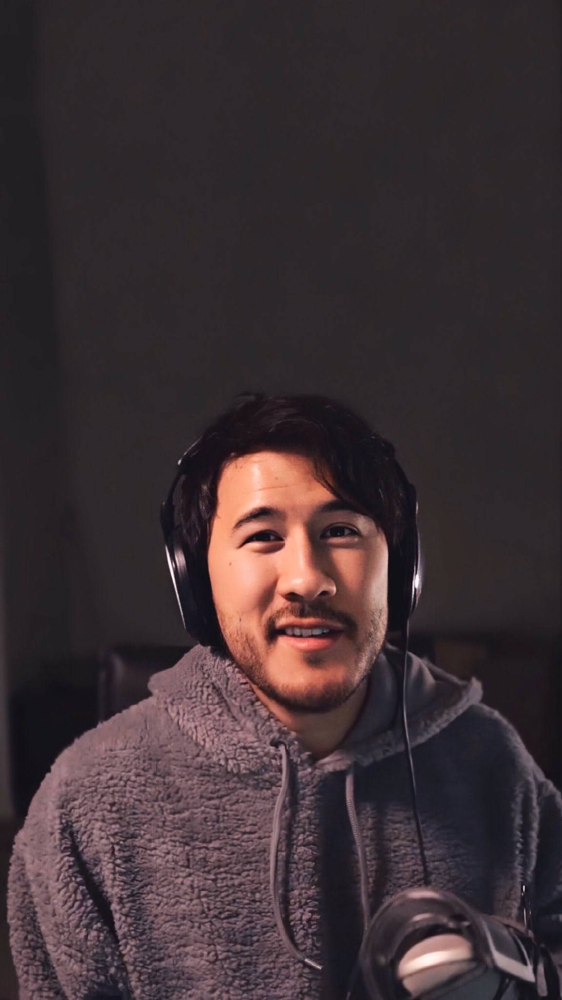 A man wearing headphones and holding something - Markiplier