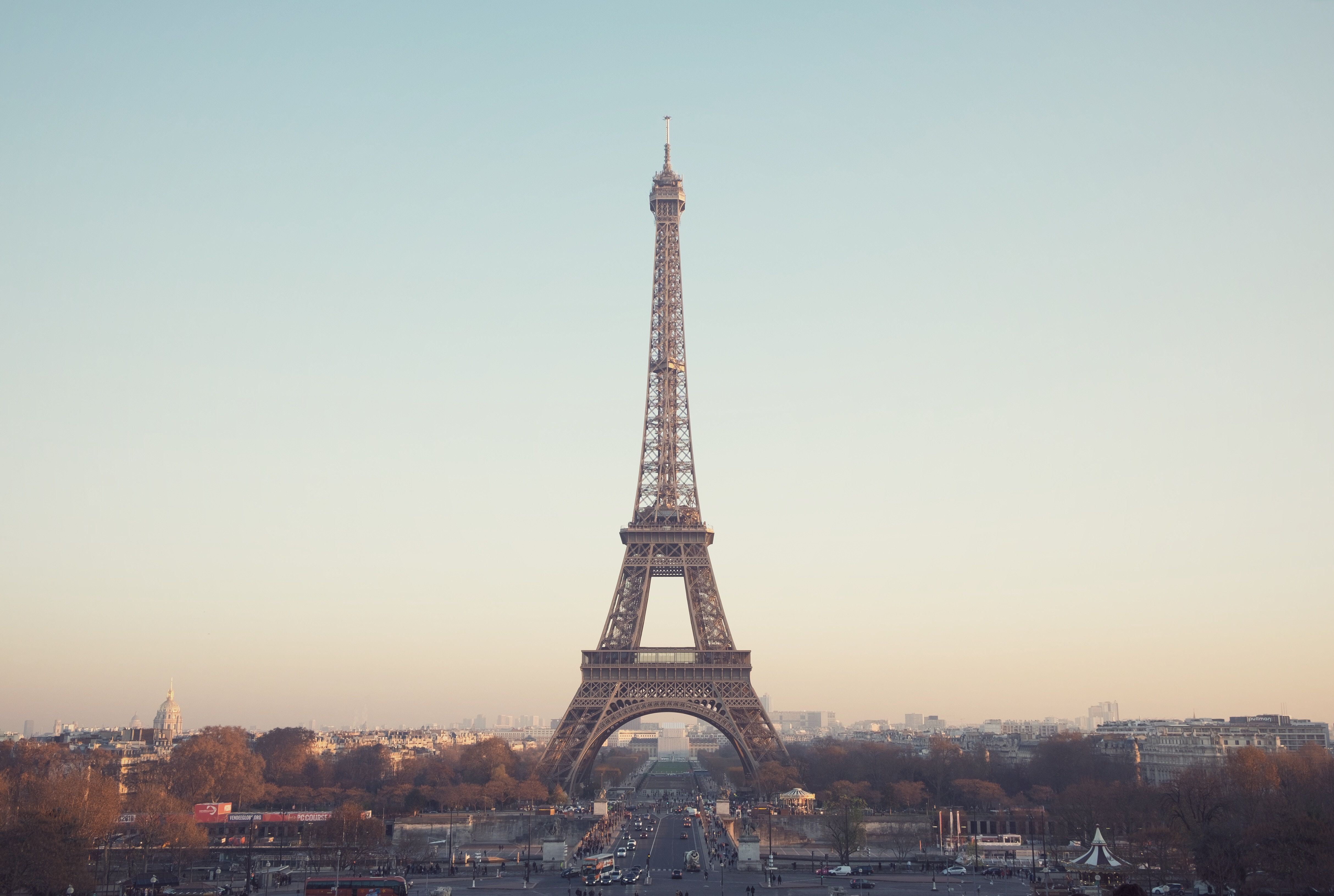 A tall building with cars and people in the foreground - Paris