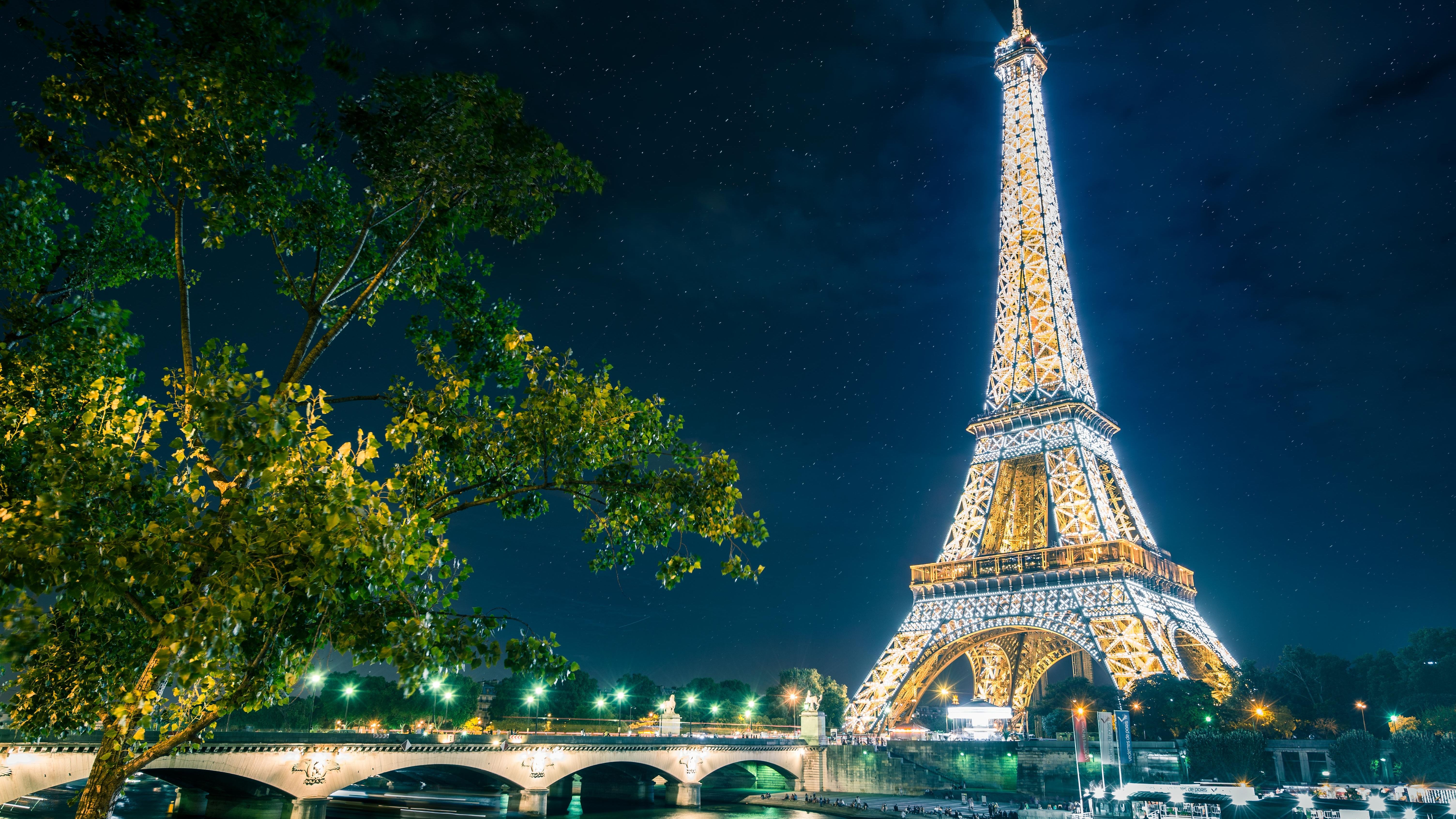 The eiffel tower is lit up at night - Paris