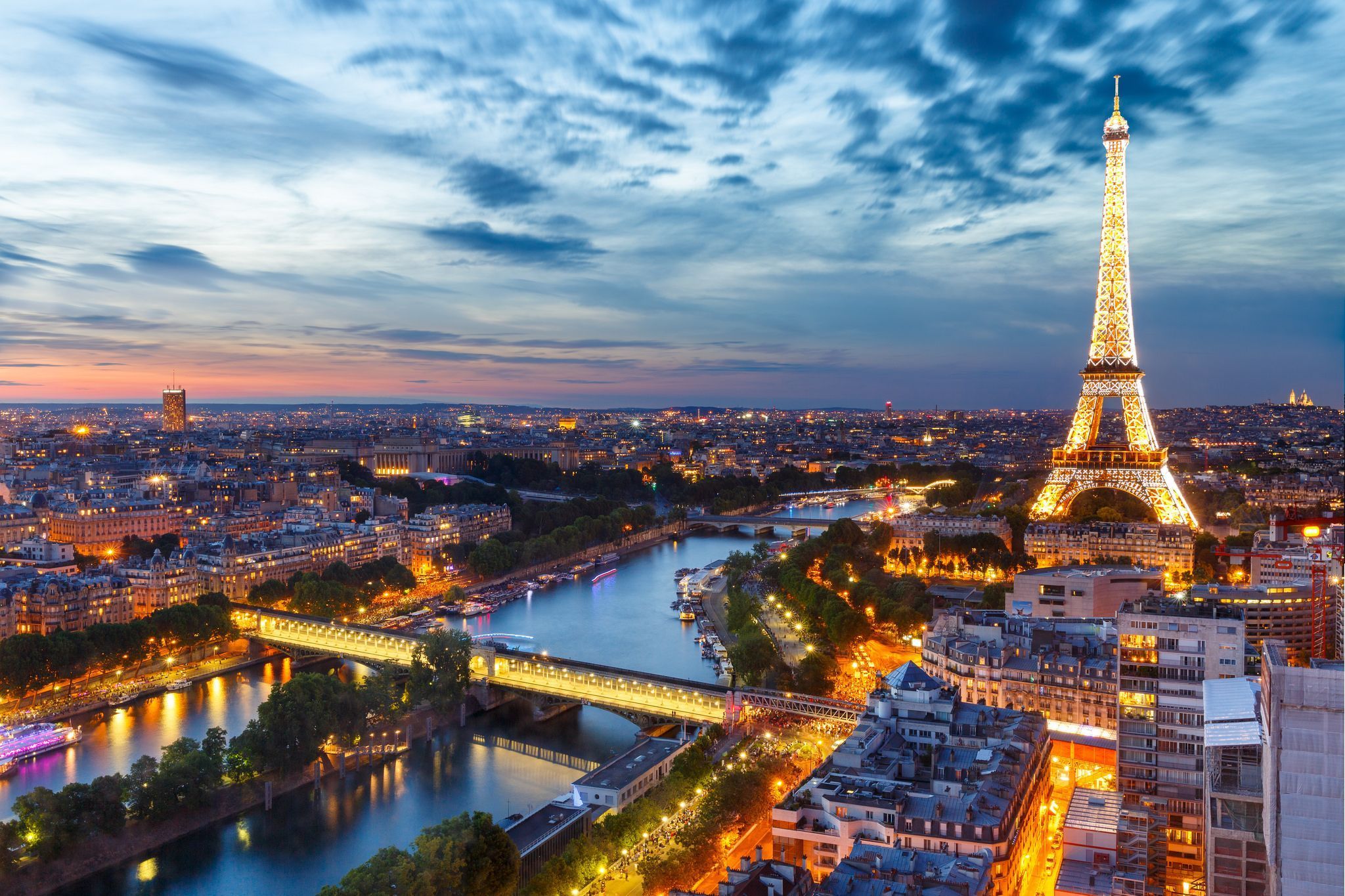 The eiffel tower is lit up at night - Paris