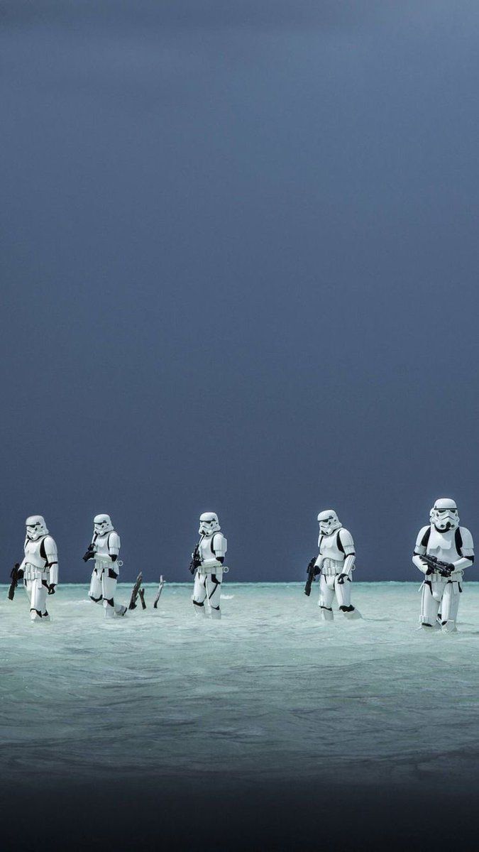 A group of storm troopers walking in the sand - Star Wars