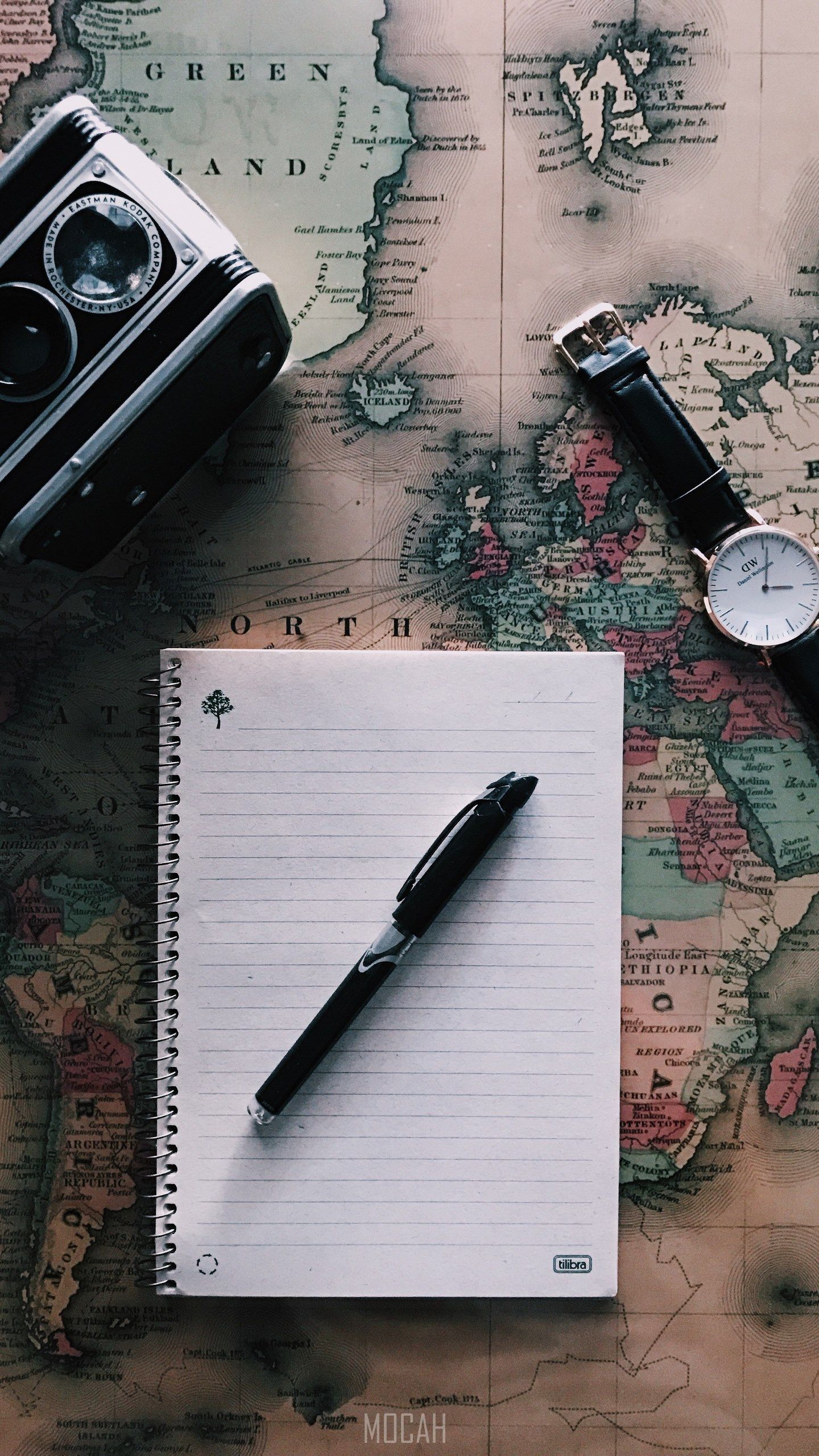 A notepad, pen, watch and camera on a map - Travel