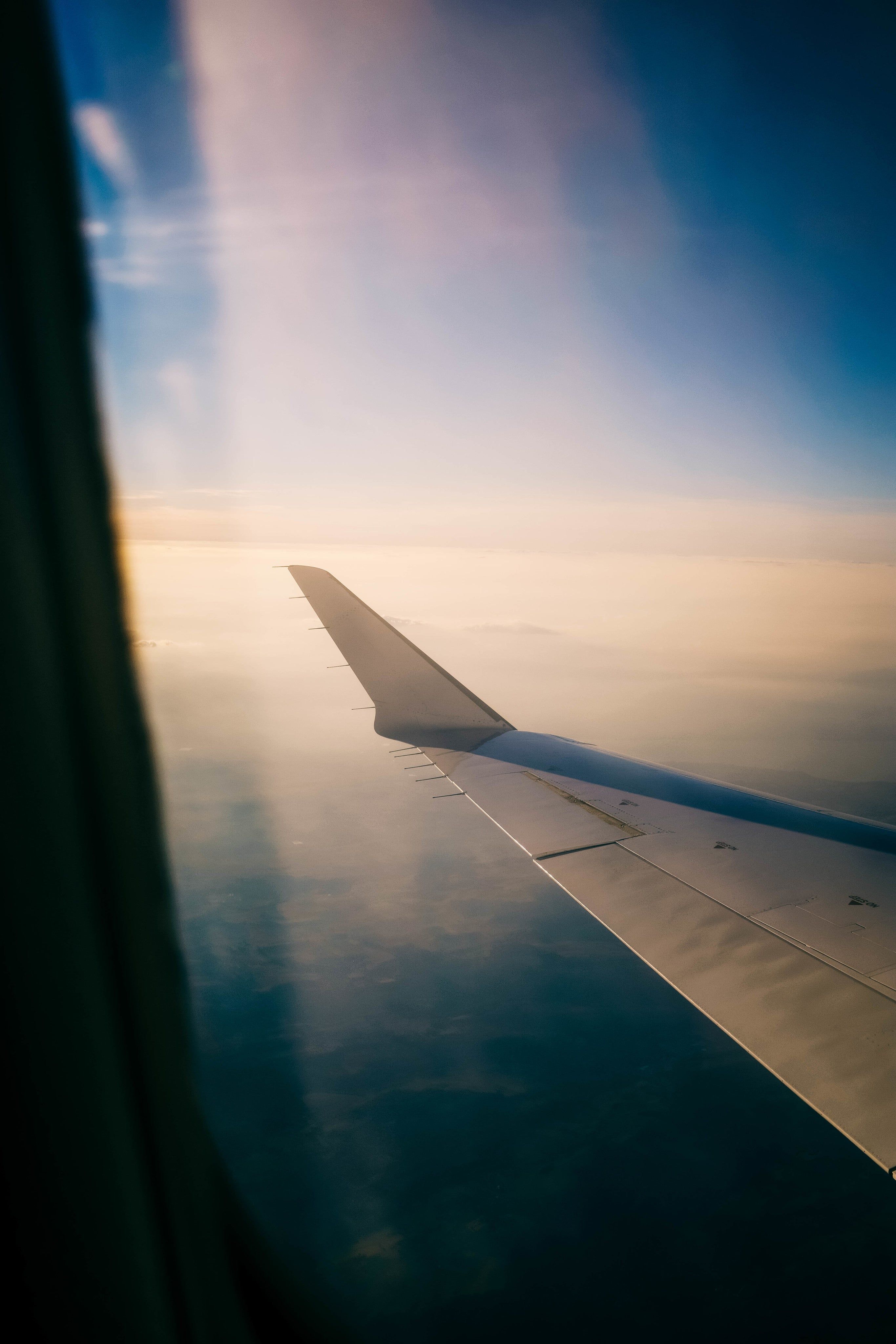 A photo of a plane wing taken from inside the plane. - Travel
