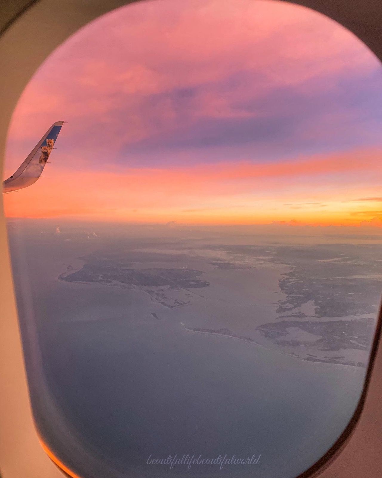 A window of an airplane looking out over the ocean - Travel