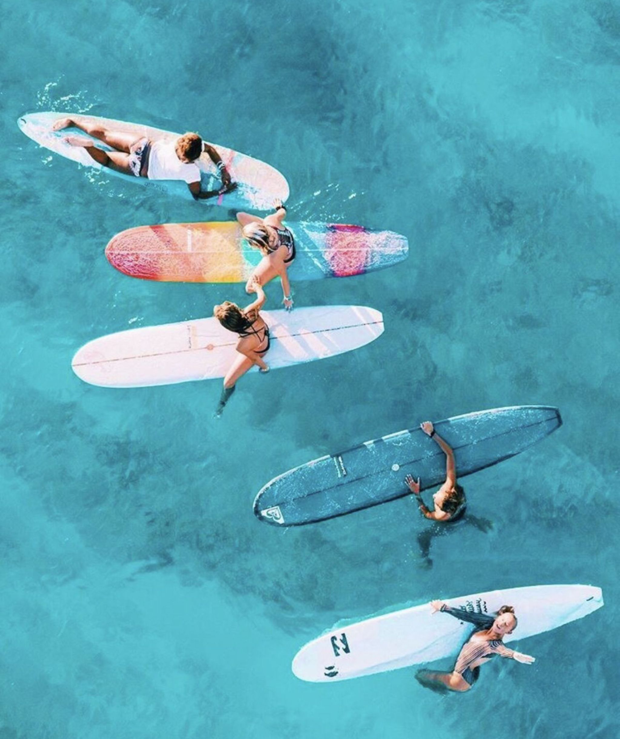 A group of people on surfboards in the ocean - Surf