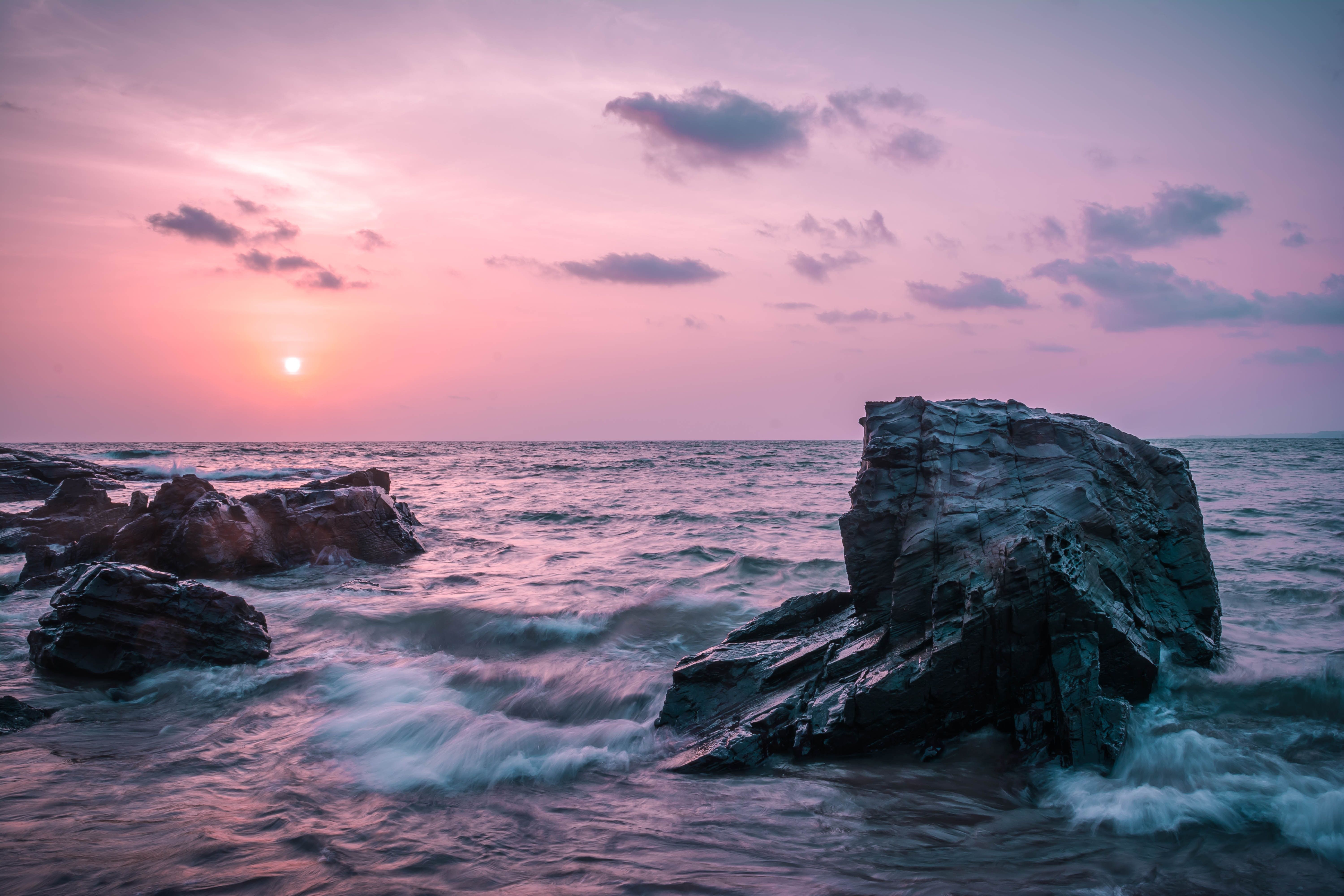A photo of a beautiful sunset over the ocean with a rock in the foreground. - Landscape, sunrise