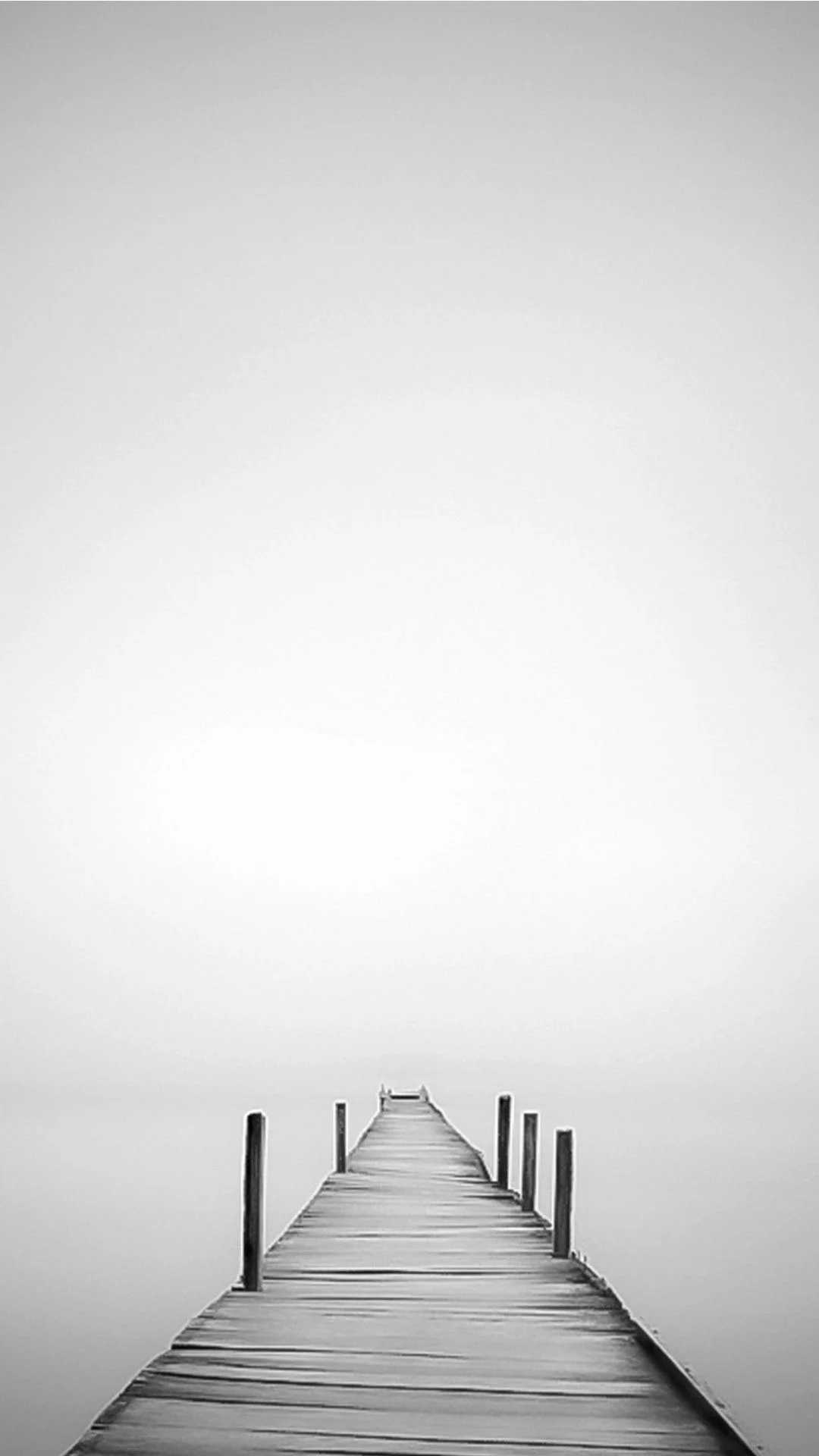 A black and white photo of an empty pier - White