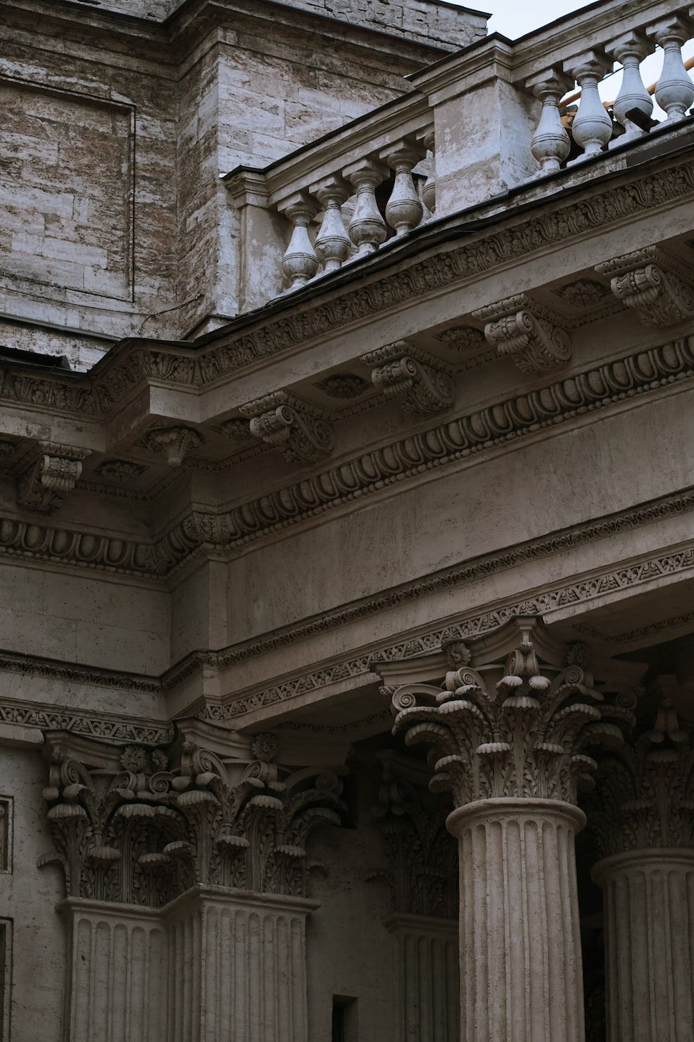 An architectural detail of a building with columns and decorative details. - Architecture