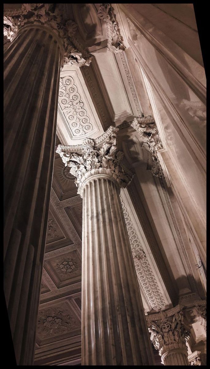 An up-close shot of the interior of a building with columns and a ceiling. - Architecture