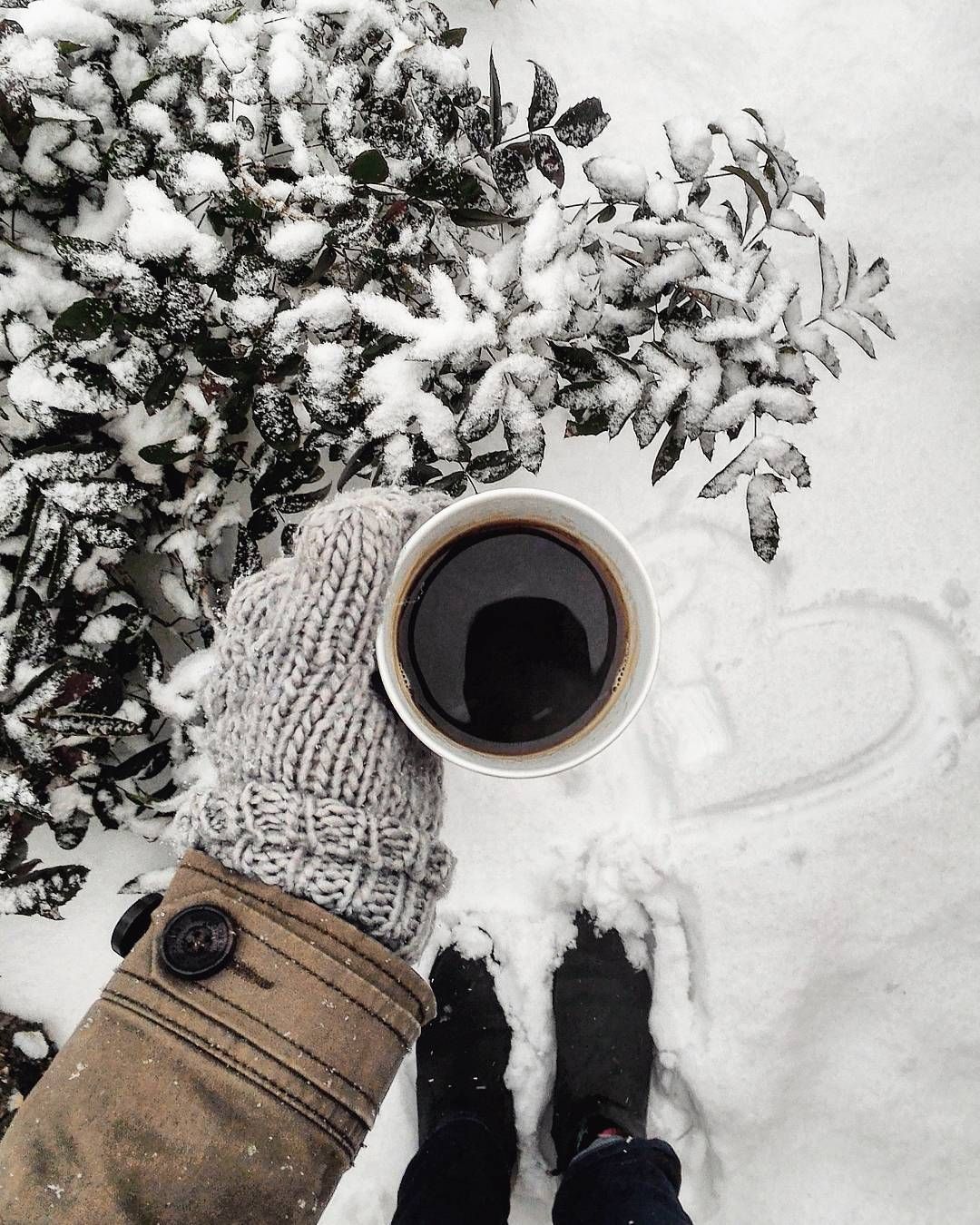 A person holding up their coffee cup in the snow - Coffee