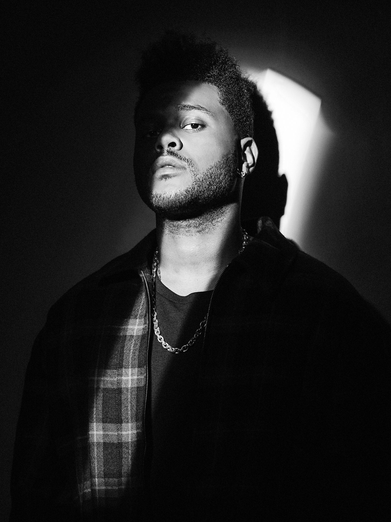 The Weeknd poses in a black and white photo - The Weeknd