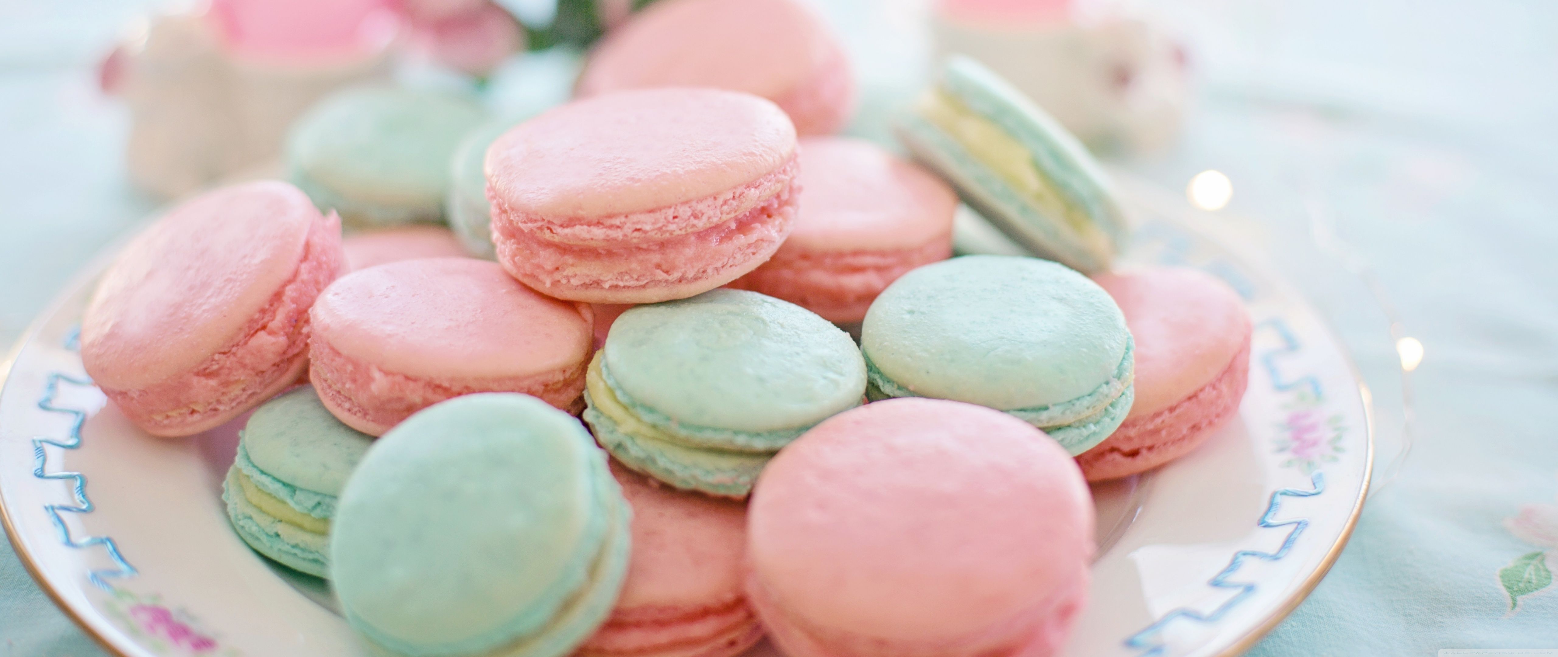 Macaroons on a plate, some pink and some blue, with a blue tablecloth. - Pastel, macarons