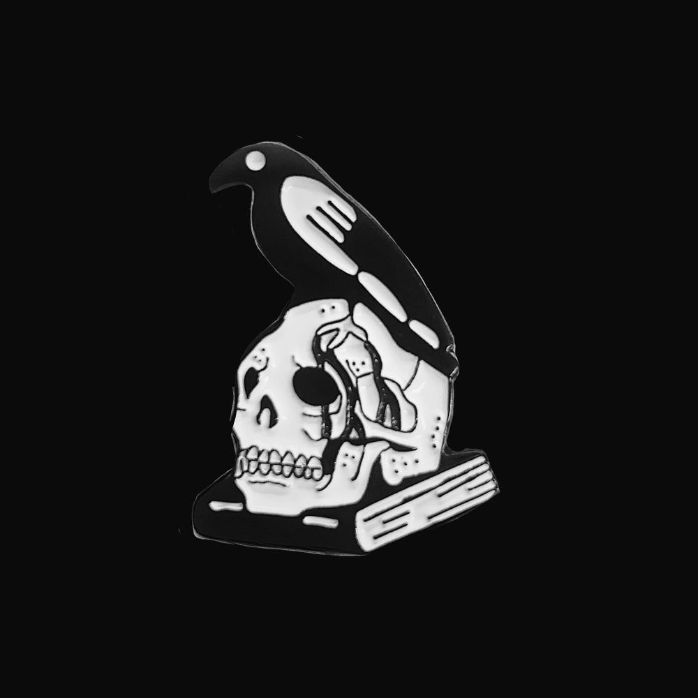 A black and white lapel pin with a skull and crow. - Skeleton, skull