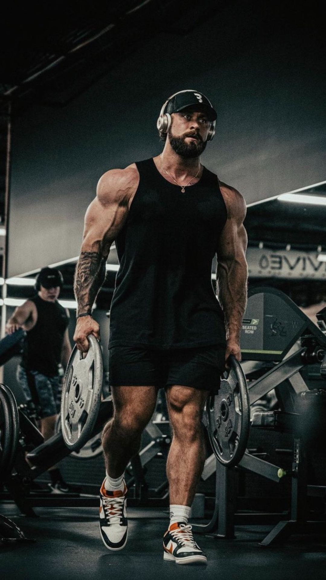 A man in the gym holding weight plates - Gym