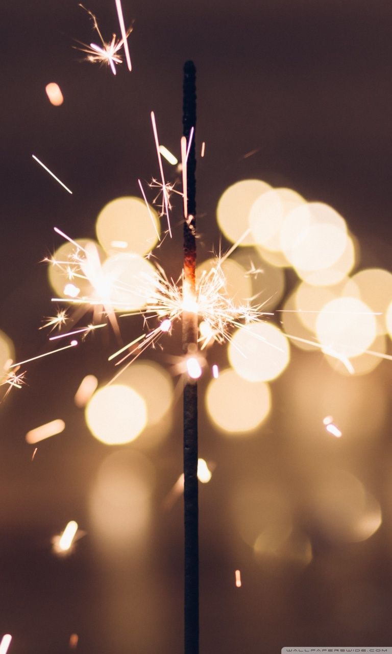 A sparkler is lit up in the dark - New Year