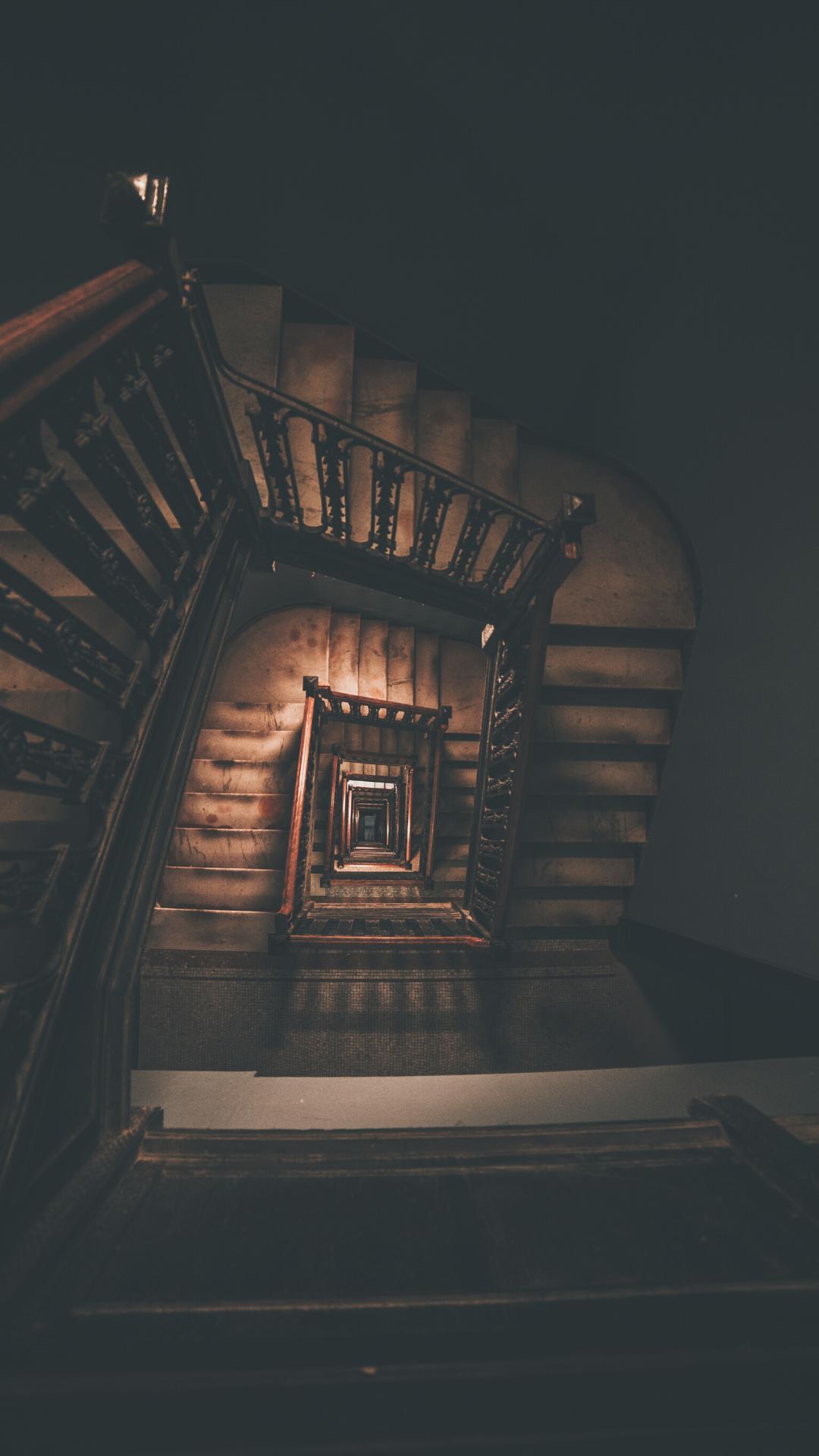 A dark stairwell with a spiral staircase - Dark academia