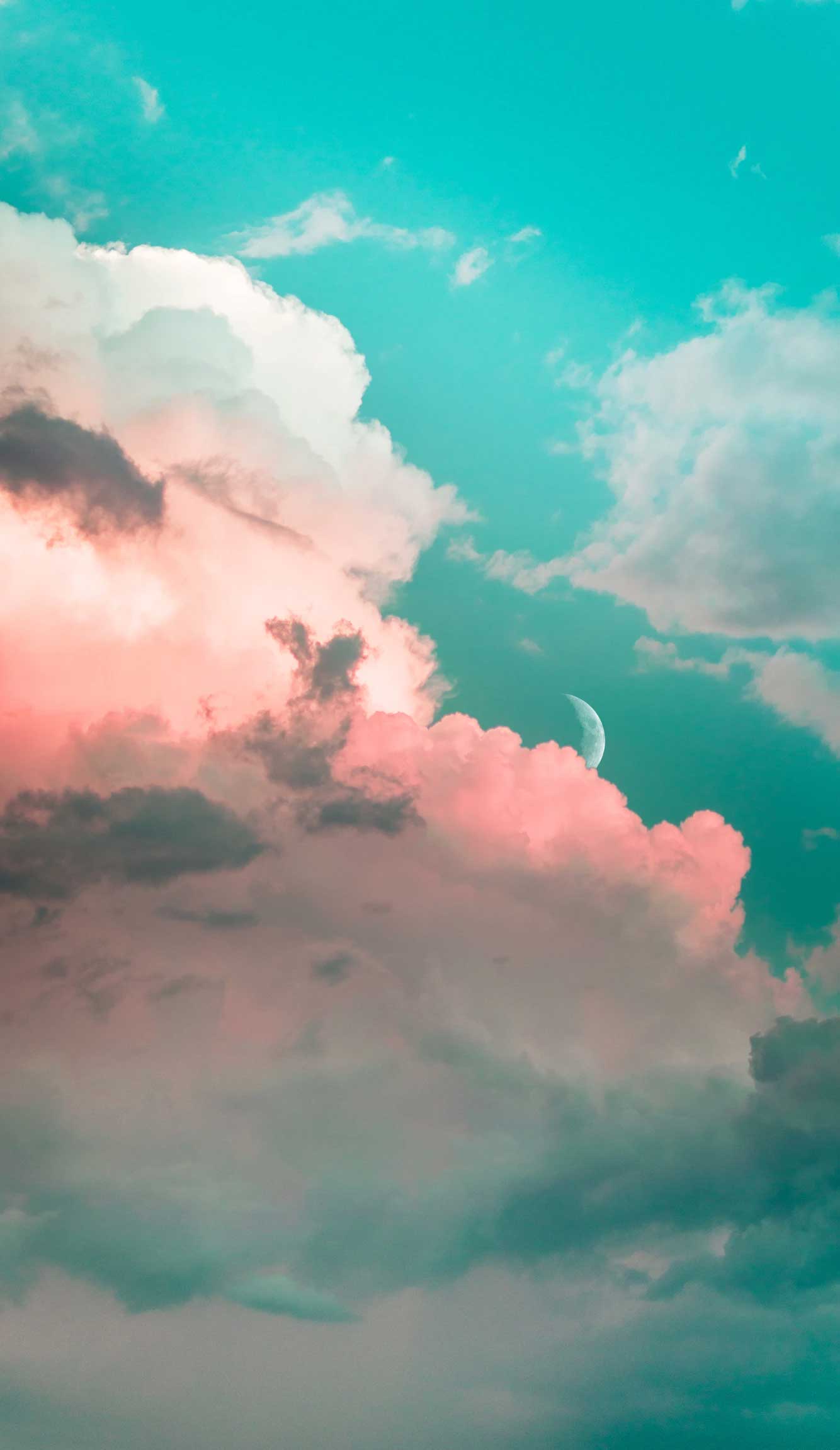 A plane flying through the clouds in front of an orange and pink sunset - Turquoise
