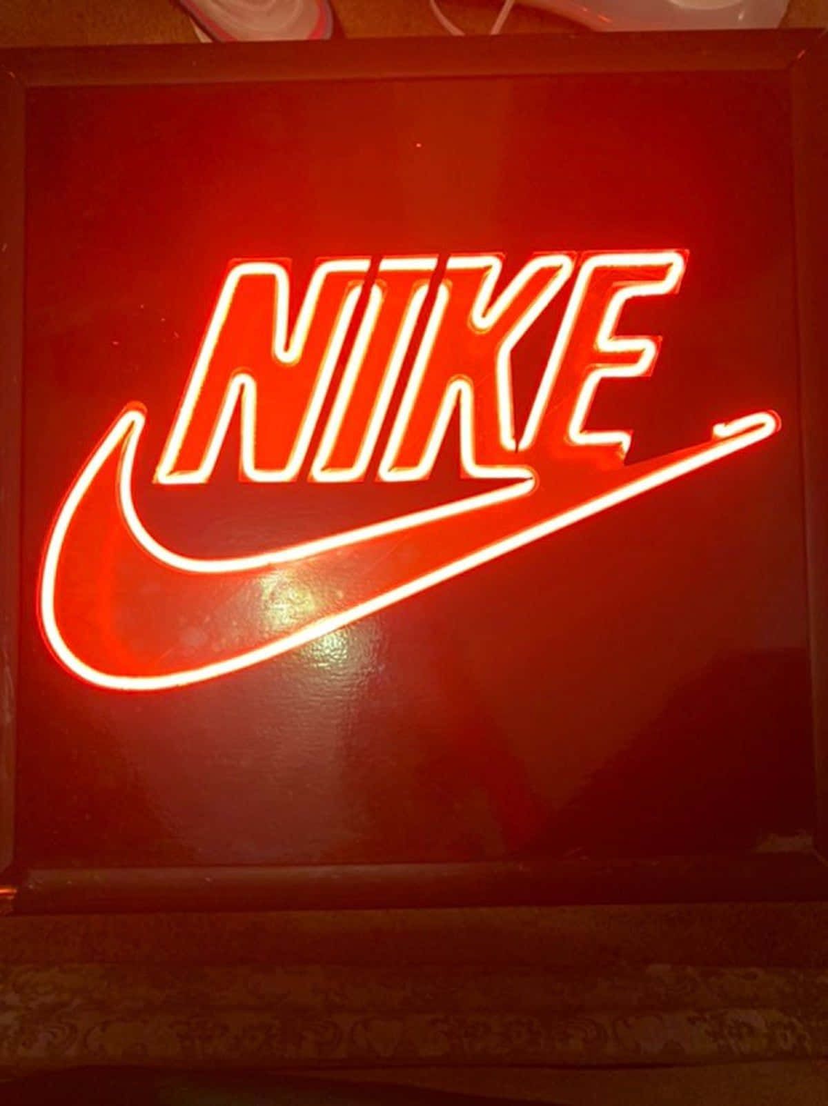 A neon sign of the Nike logo in red - Neon red