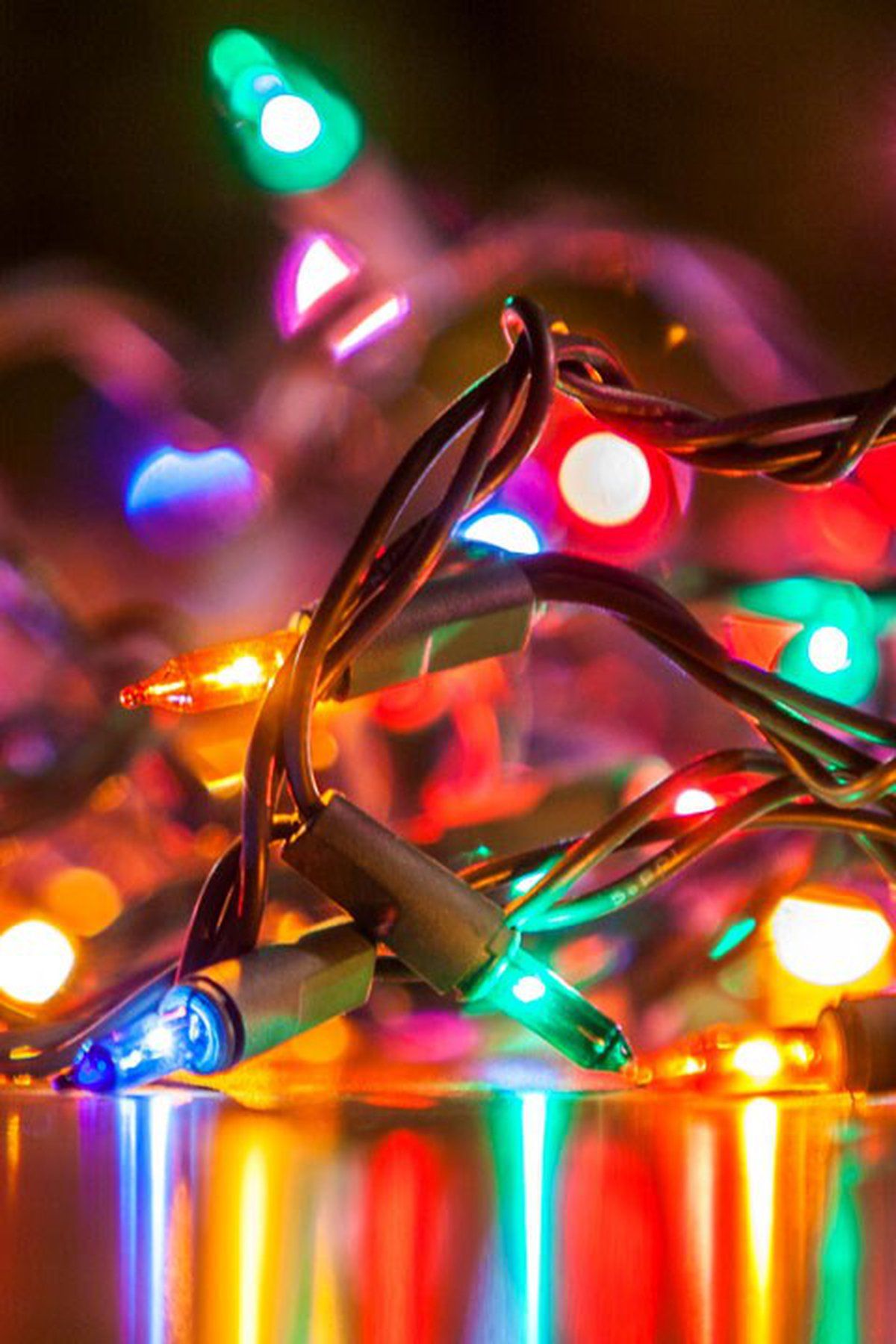 A string of Christmas lights on a reflective surface. - Christmas lights